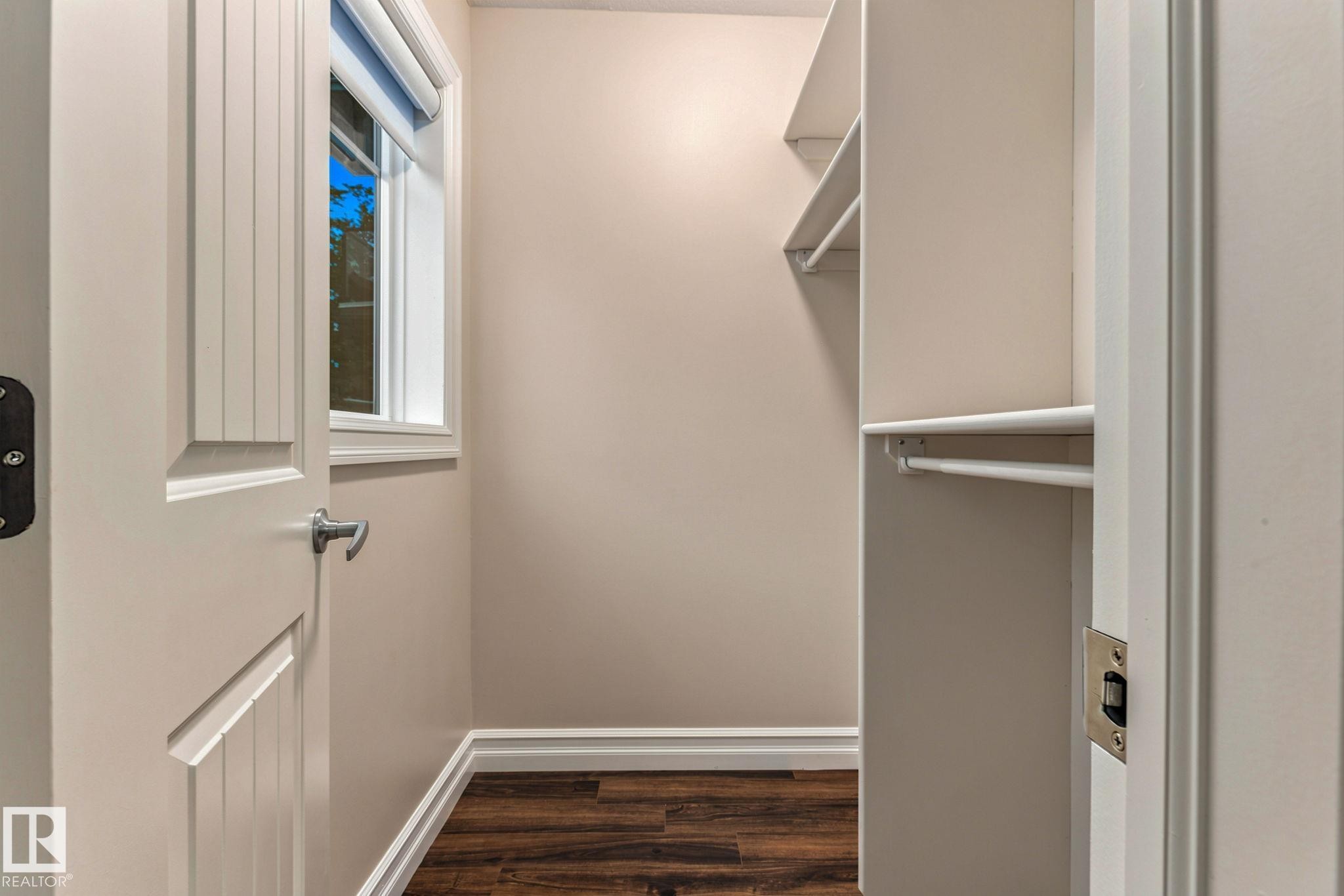 Walk-in closet featuring wood-finish flooring, built-in shelving, and a window with blinds - 10143 123 Street Nw, Edmonton, AB
