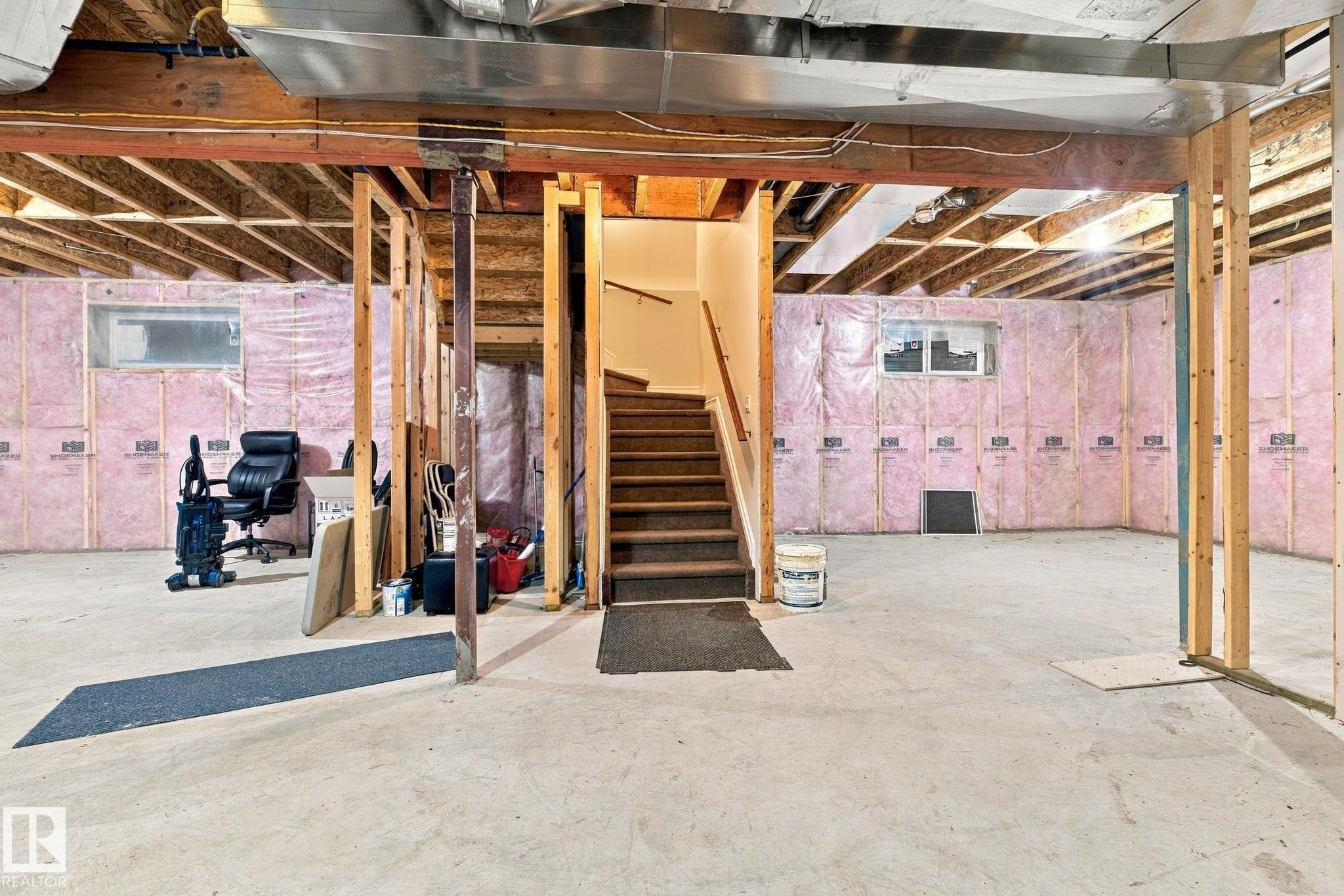 Unfinished basement featuring exposed wood framing, concrete flooring, and insulated walls - 10143 123 Street Nw, Edmonton, AB