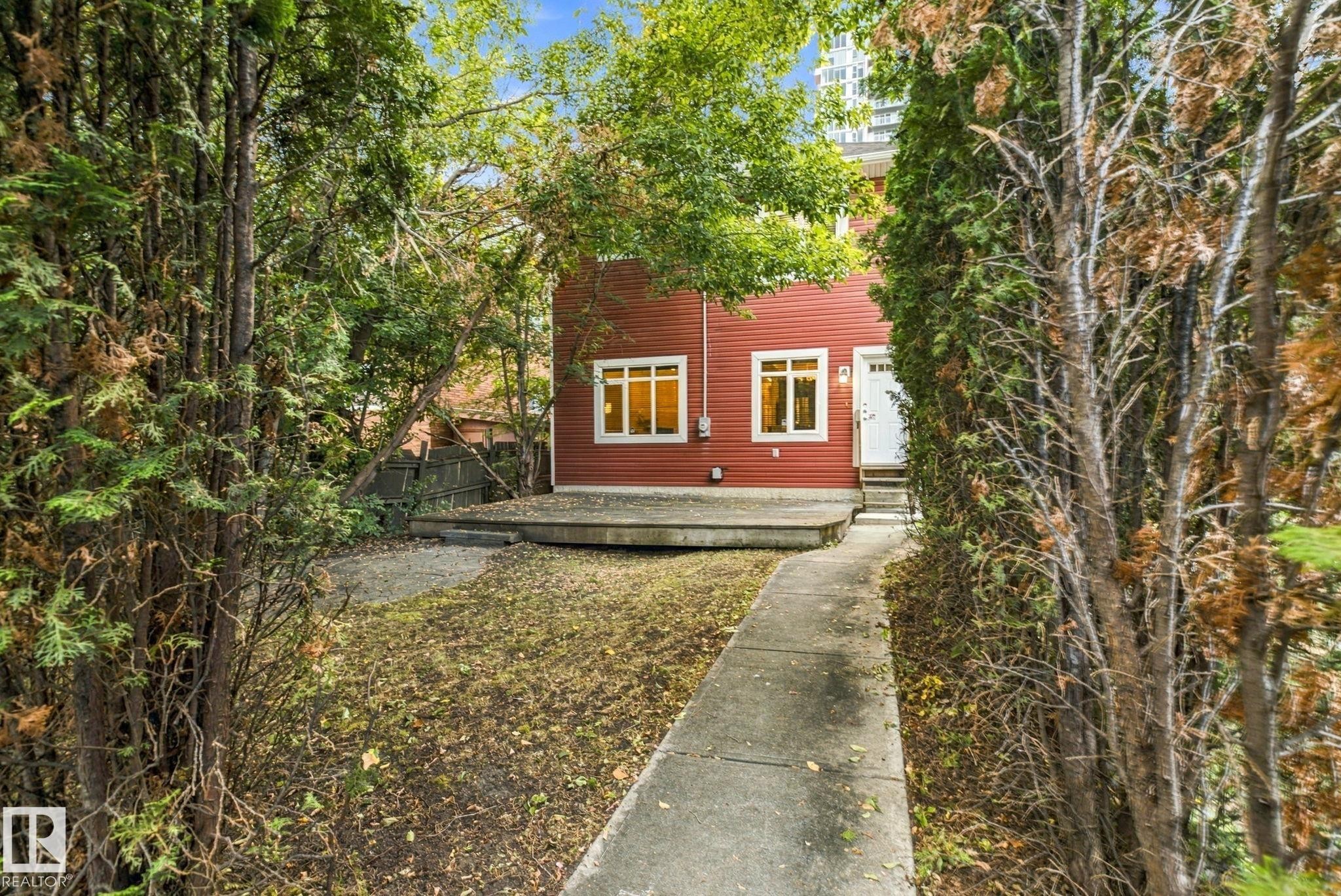 Red exterior siding with white window frames and a white entry door - 10143 123 Street Nw, Edmonton, AB