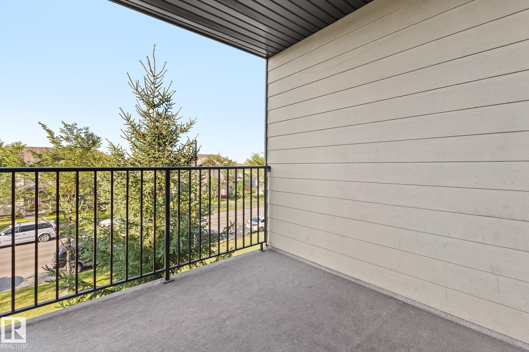 Private balcony with concrete flooring, black metal railing, and horizontal siding - #306 530 Watt Bv Sw, Edmonton, AB