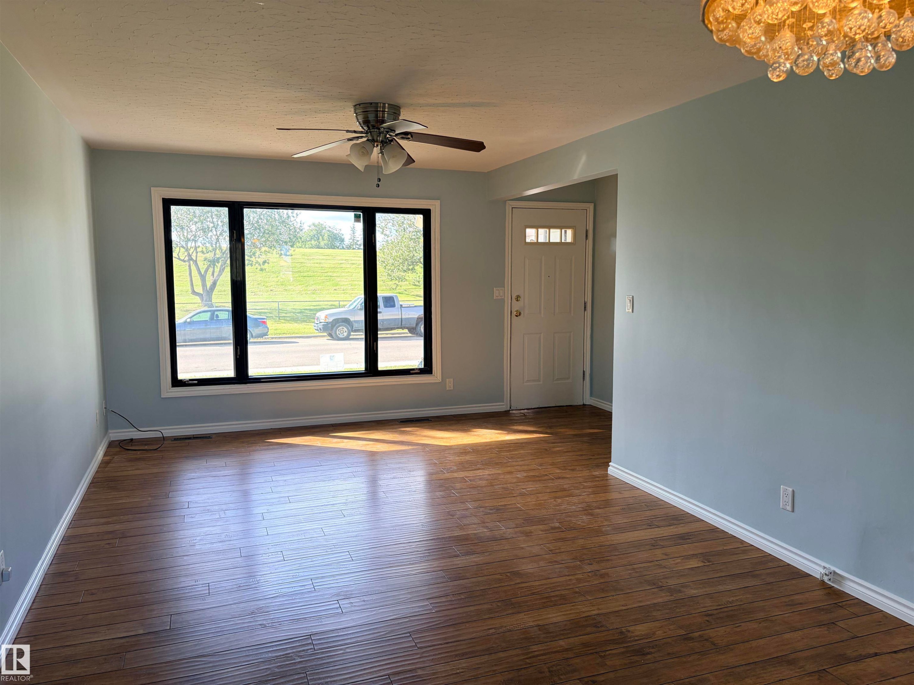 Wood-finish flooring throughout, complemented by light-colored walls - 13219 107 Street Nw, Edmonton, AB