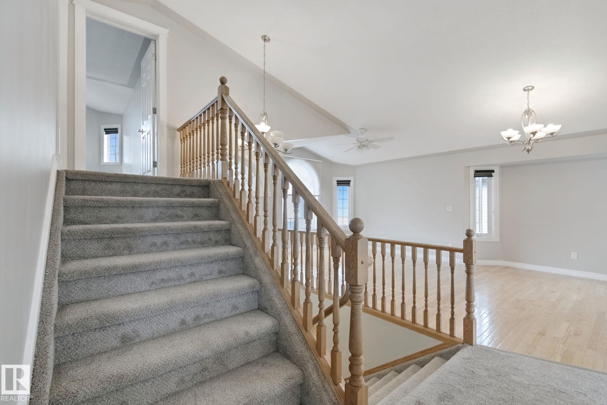 Carpeted staircase with wood banister - 16807 78 Street Nw, Edmonton, AB