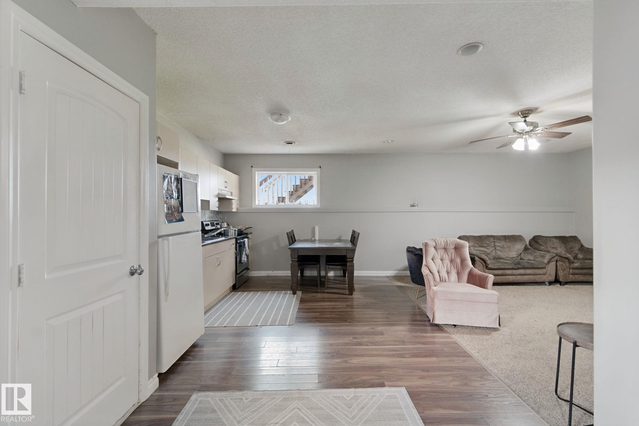 Full kitchen with white appliances, wood-finish flooring, recessed lighting, and a ceiling fan - 16807 78 Street Nw, Edmonton, AB