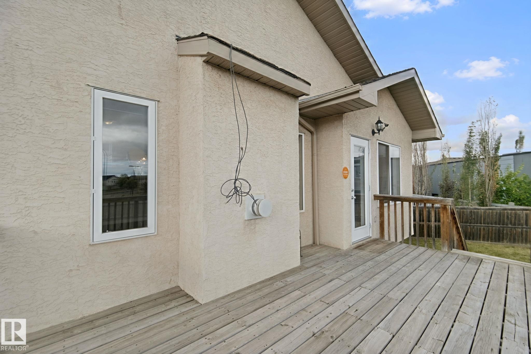 Exterior stucco finish and a wood deck with wood railing - 16807 78 Street Nw, Edmonton, AB