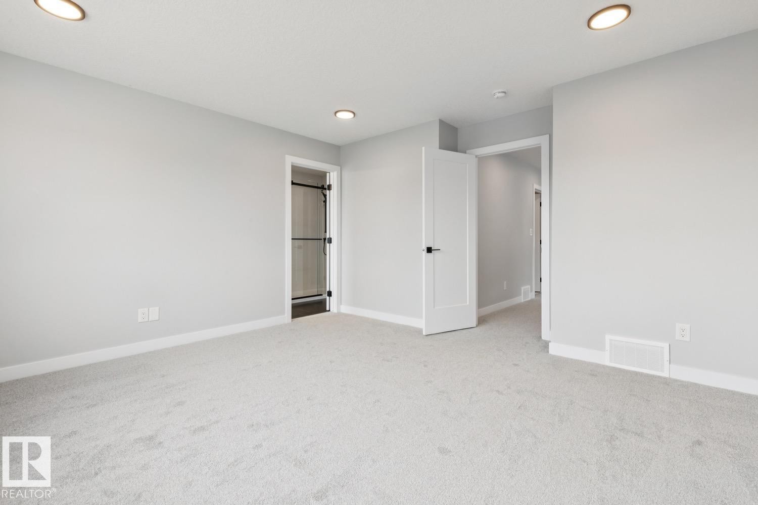 Neutral carpeting, recessed lighting, and white trim - 72 Maple Crescent, Gibbons, AB