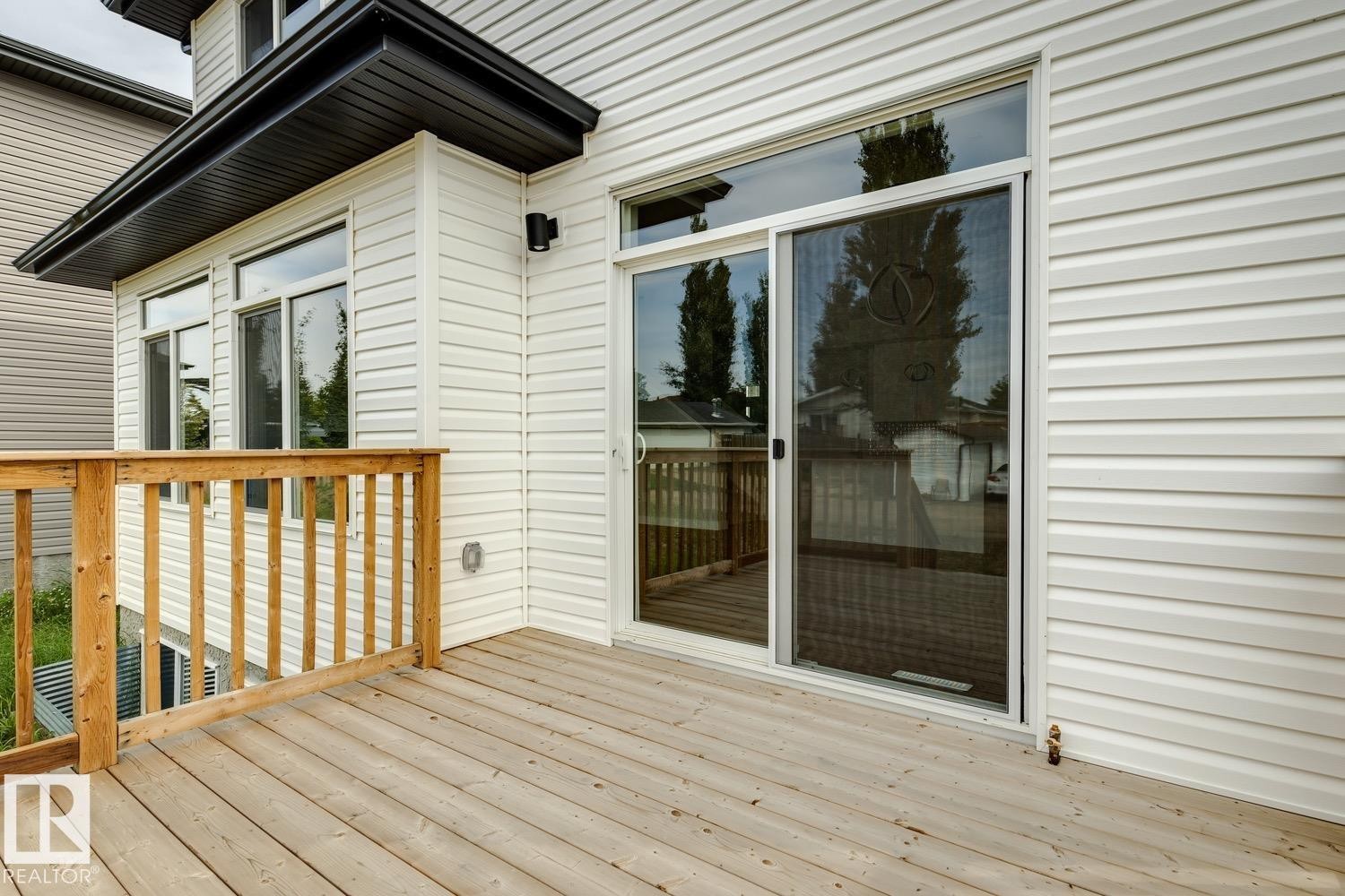 Wood-finish deck with a natural wood railing - 72 Maple Crescent, Gibbons, AB