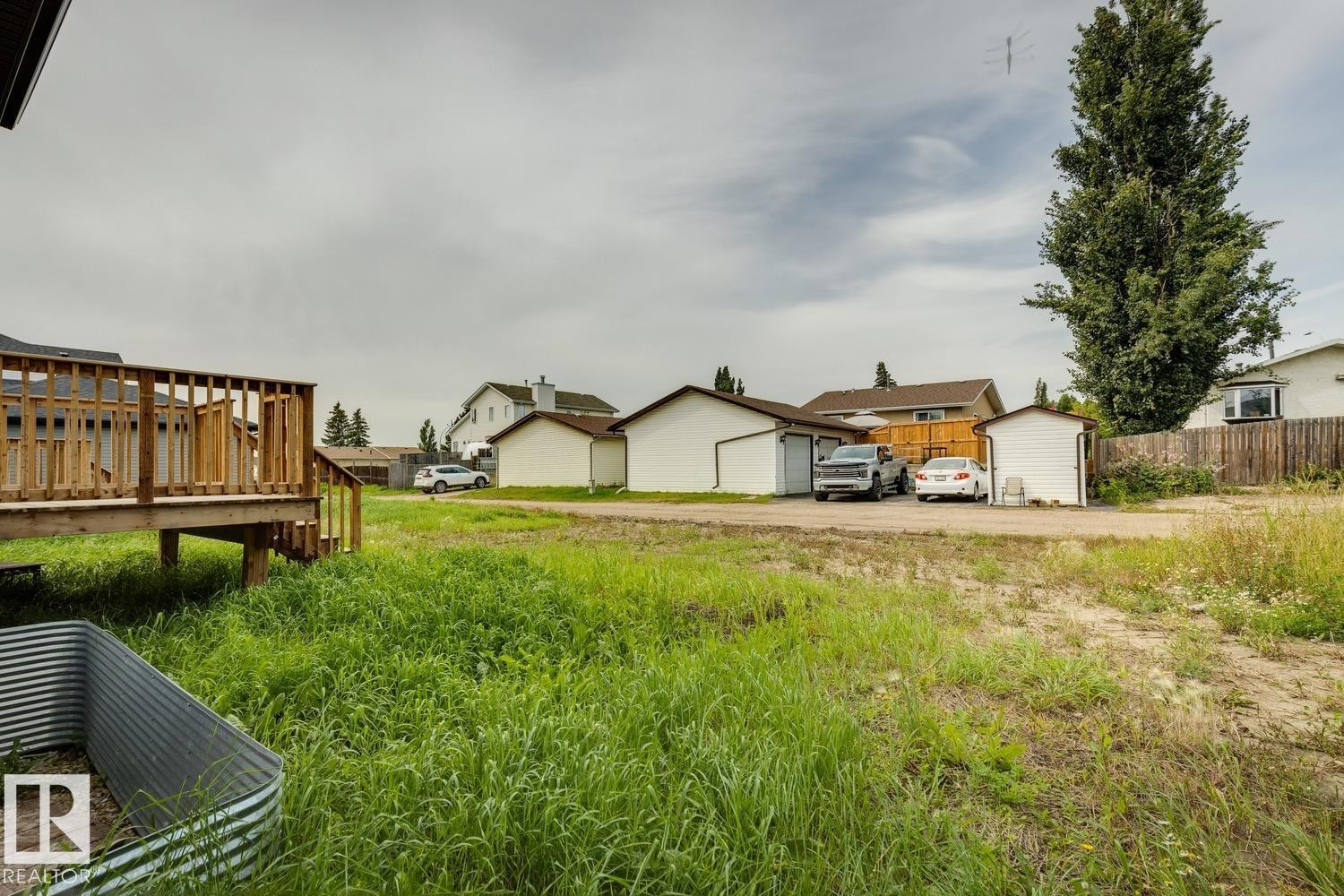 Raised wood deck with railings and steps - 72 Maple Crescent, Gibbons, AB