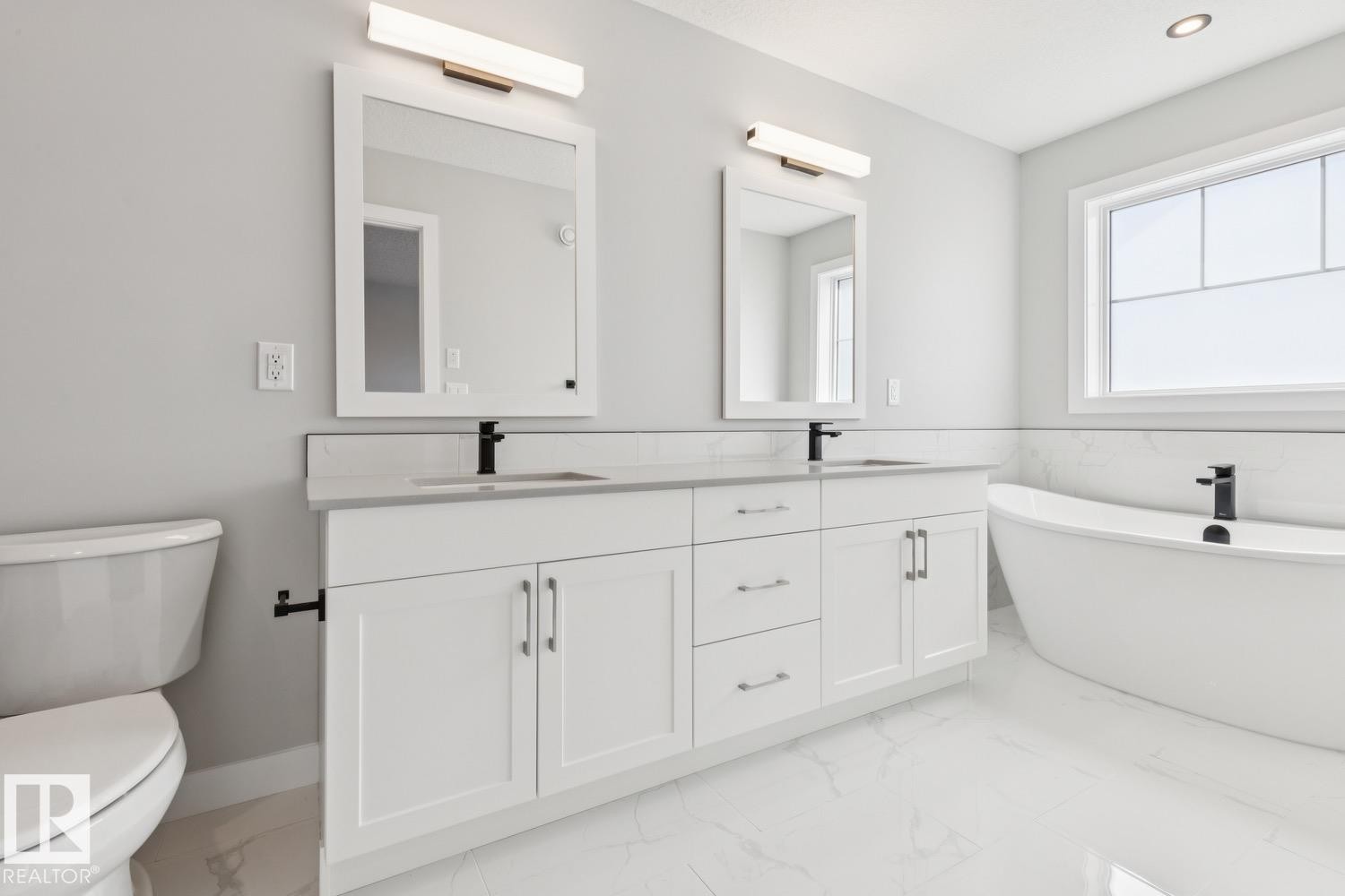 Dual vanity with white cabinetry, matte black fixtures, and light-toned countertops - 36 Maple Crescent, Gibbons, AB