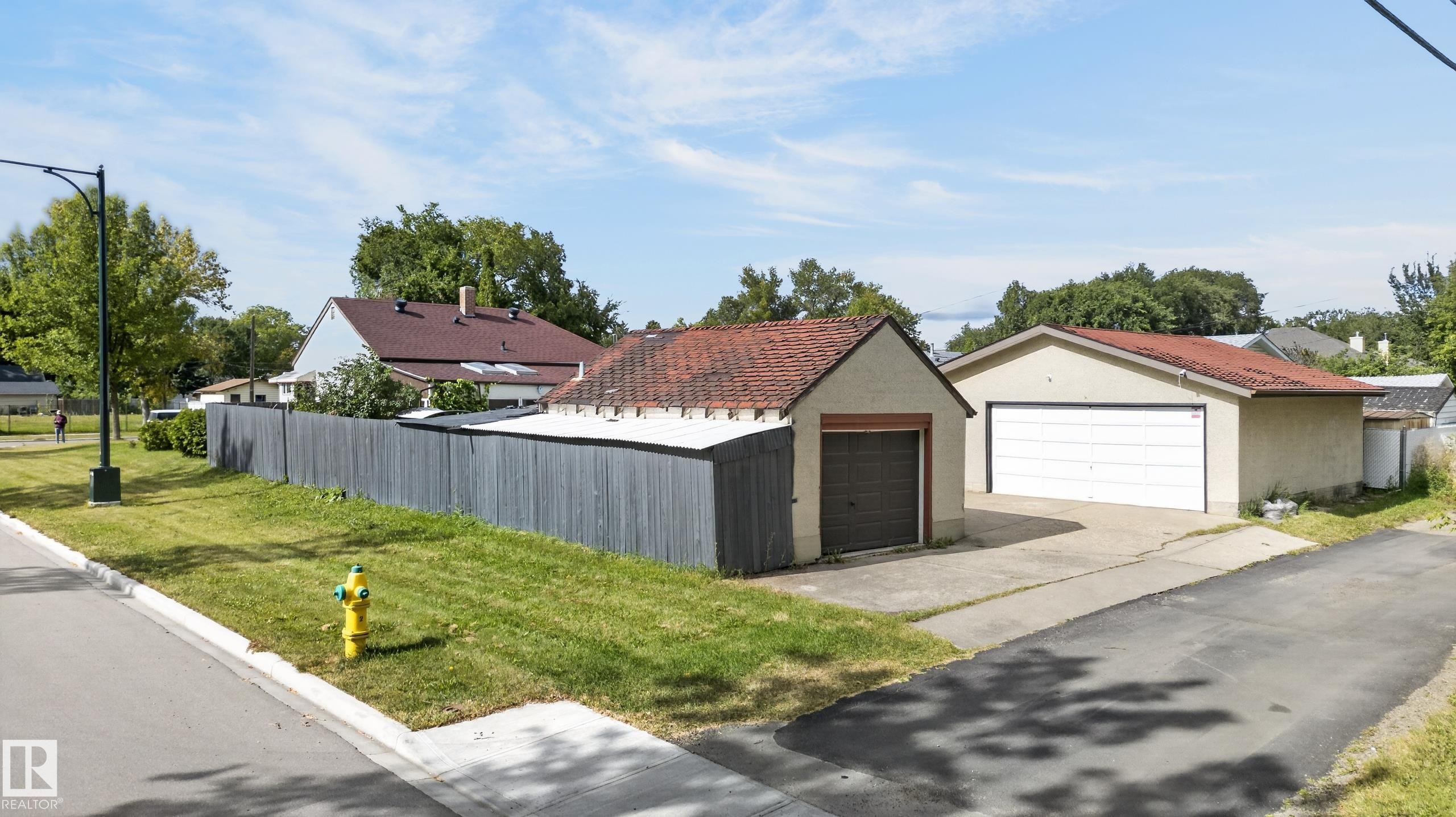 Two separate detached garages with pitched roofs, concrete driveways, and a private perimeter fence - 12309 80 Street Nw, Edmonton, AB