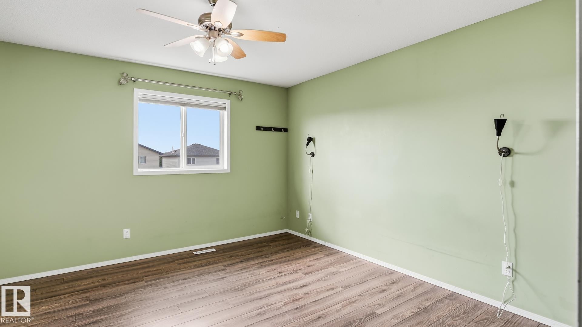 Wood-finish flooring, single window, ceiling fan with light fixture, and wall-mounted sconces - 2117 36 Avenue Nw, Edmonton, AB