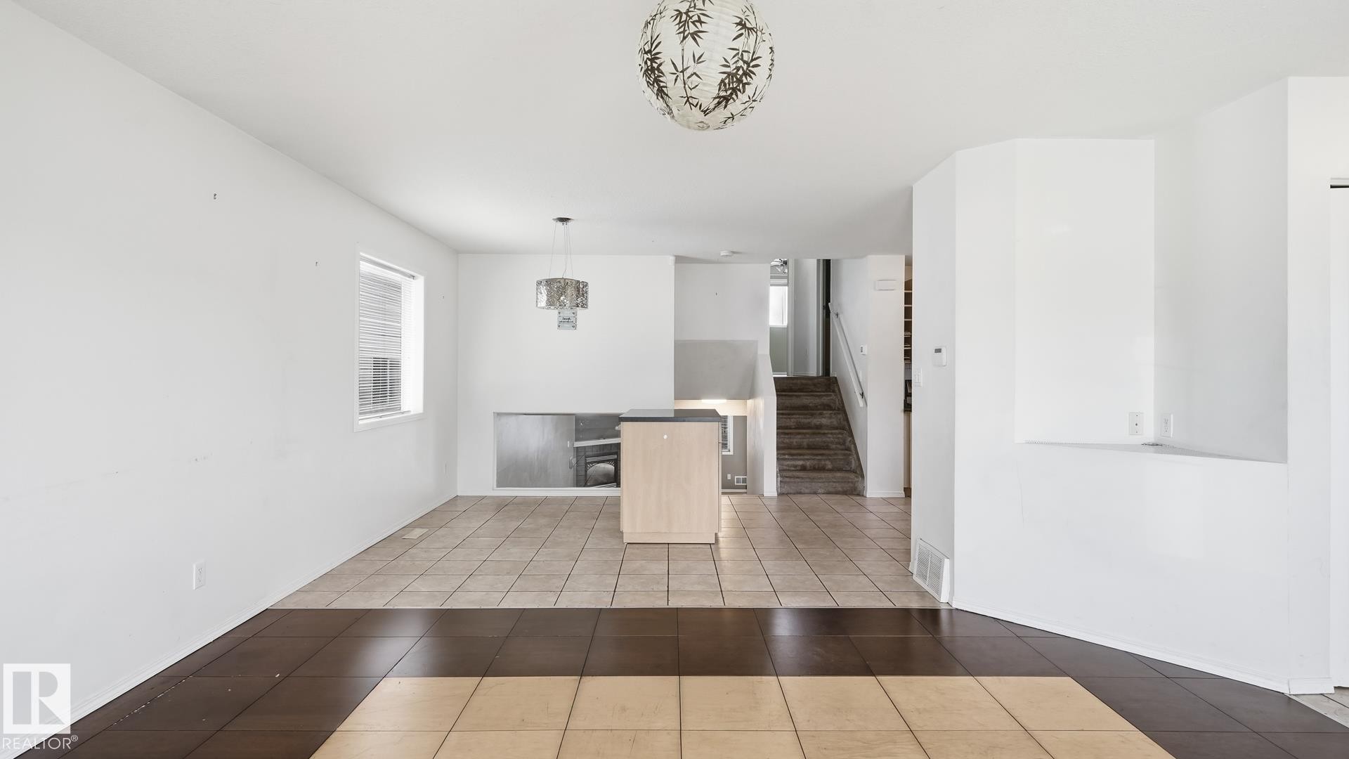Wood-finish and tile flooring, light-toned walls, and a built-in kitchen island - 2117 36 Avenue Nw, Edmonton, AB