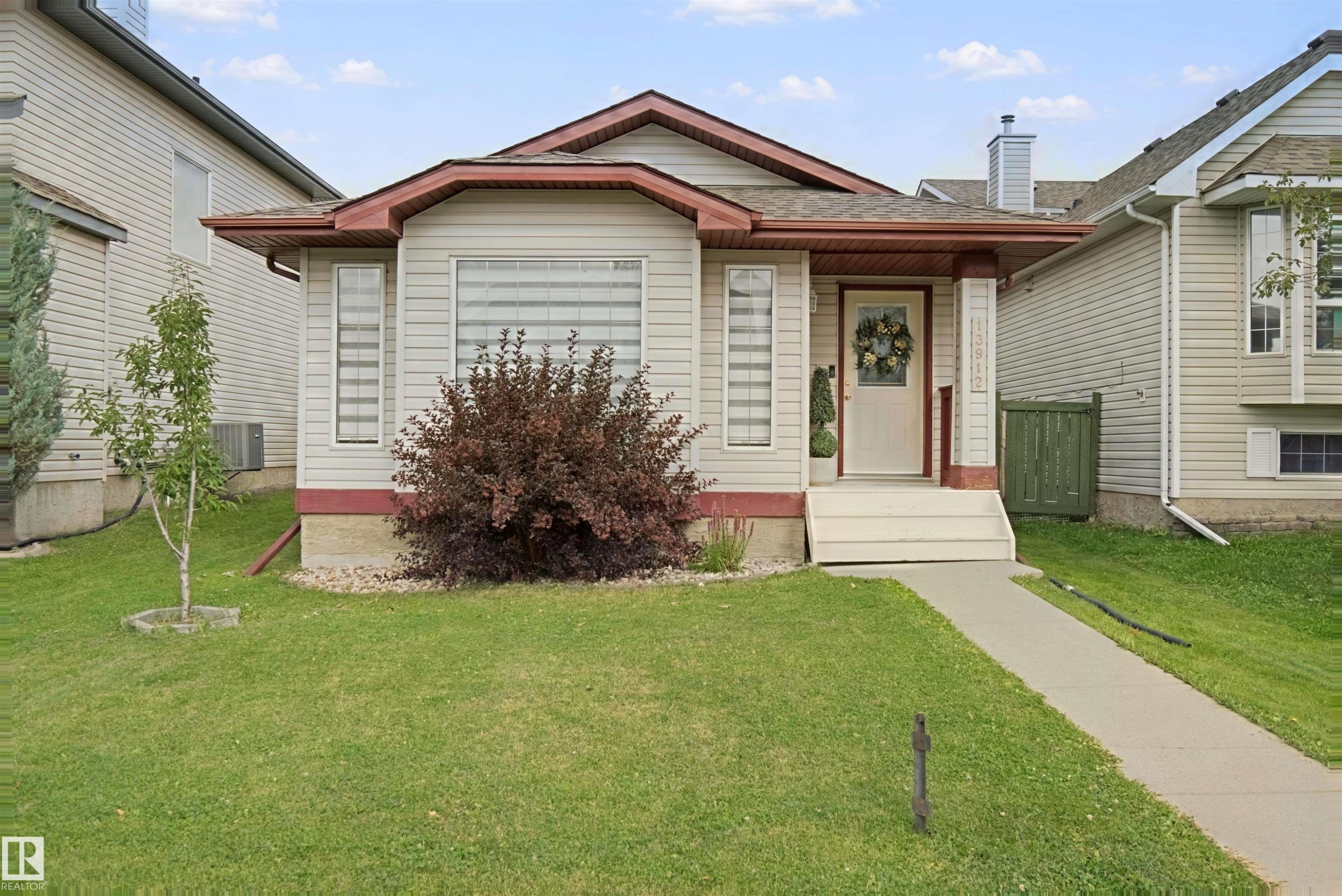 Siding exterior with contrasting trim, covered front porch, and front entry with sidelight windows - 13912 156 Avenue Nw, Edmonton, AB