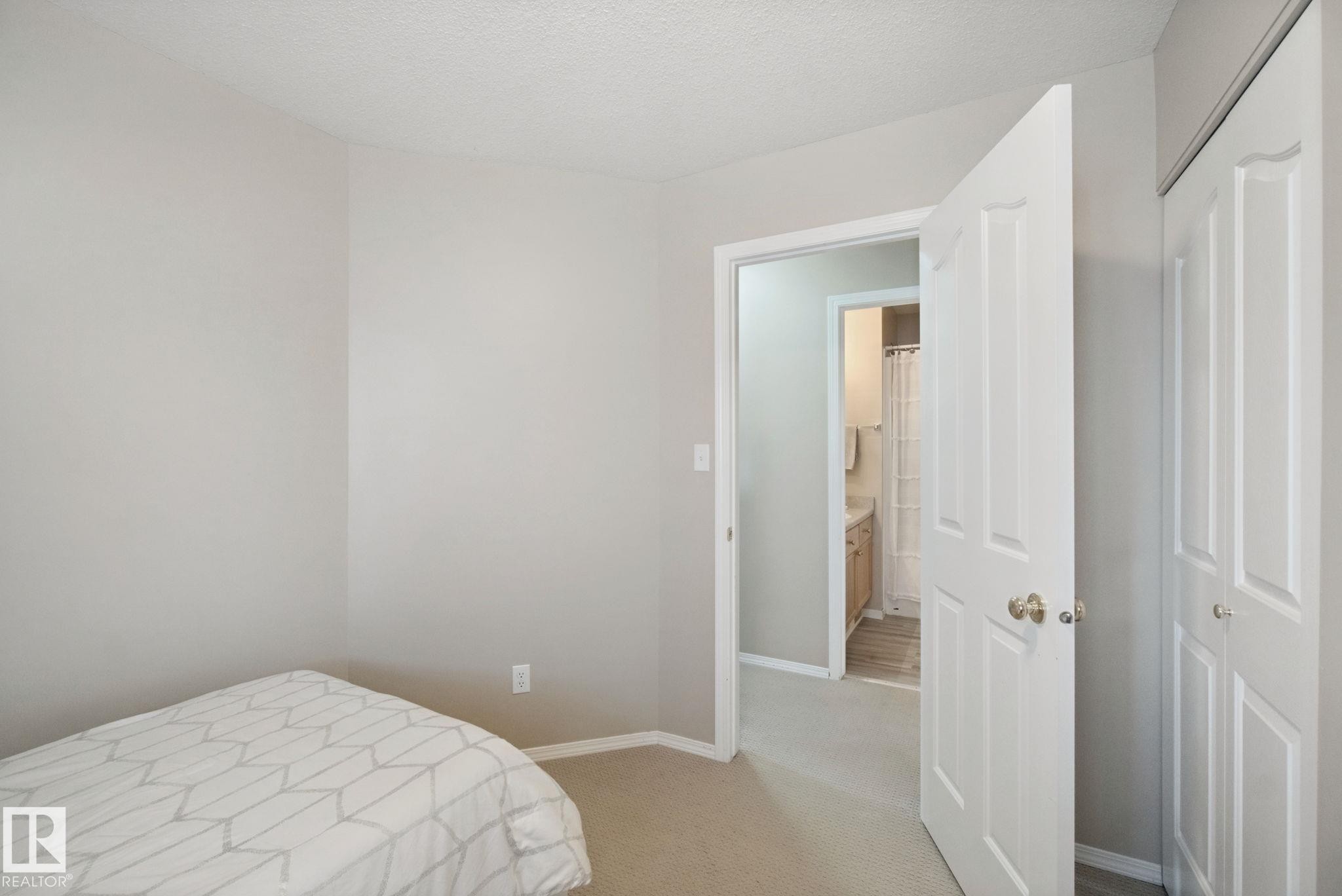 Neutral tone wall paint, carpet flooring, white paneled doors, and a built-in closet - 13912 156 Avenue Nw, Edmonton, AB