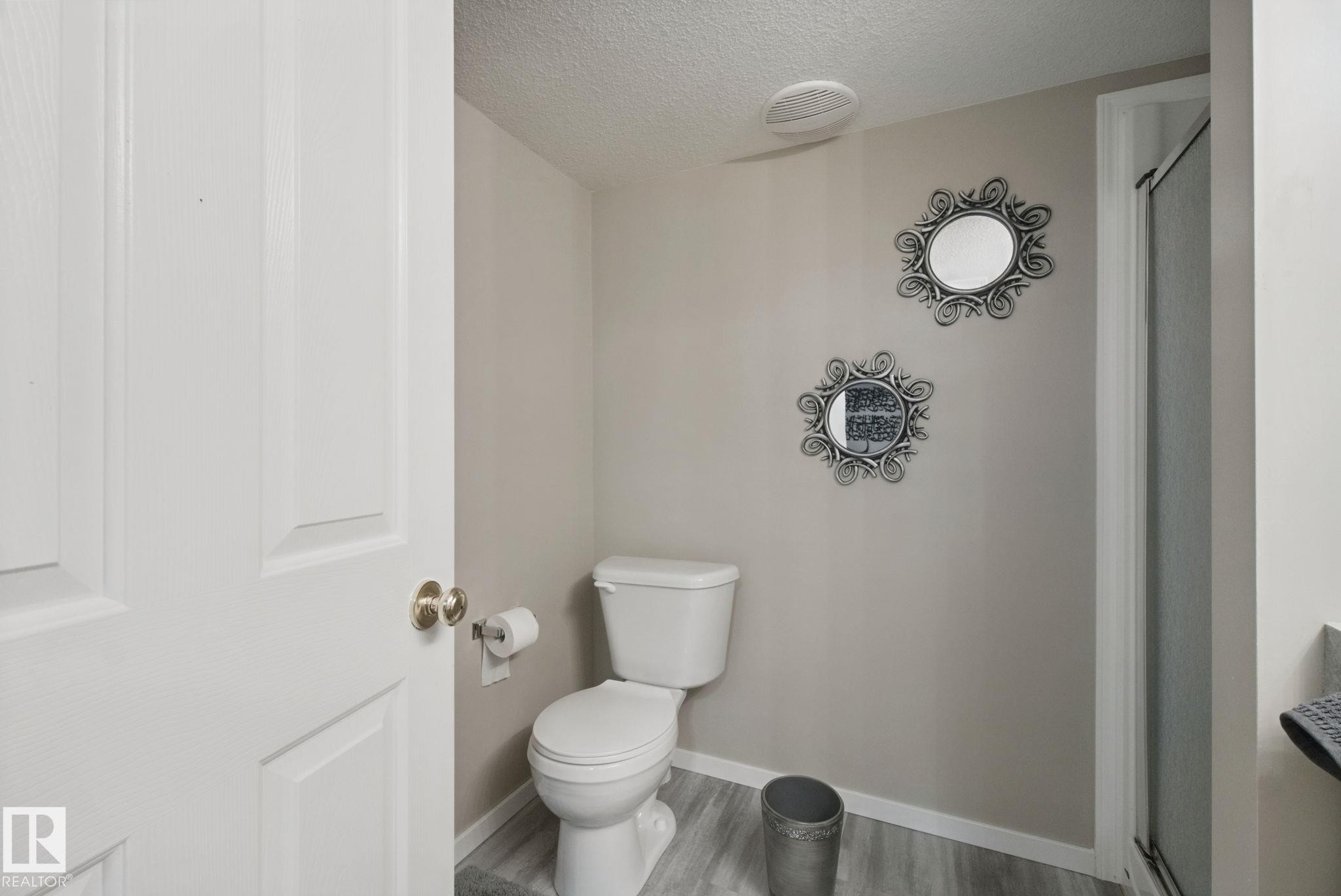 Panel interior door with brass-finish hardware, light gray wall color, and wood-finish flooring - 13912 156 Avenue Nw, Edmonton, AB