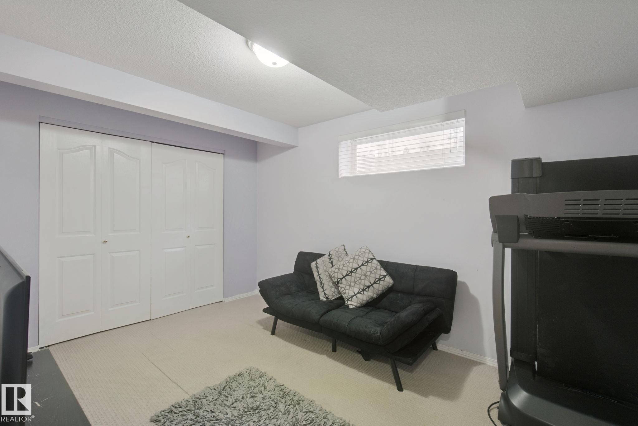 Recessed window with blinds, carpeted flooring, and bi-fold closet doors - 13912 156 Avenue Nw, Edmonton, AB
