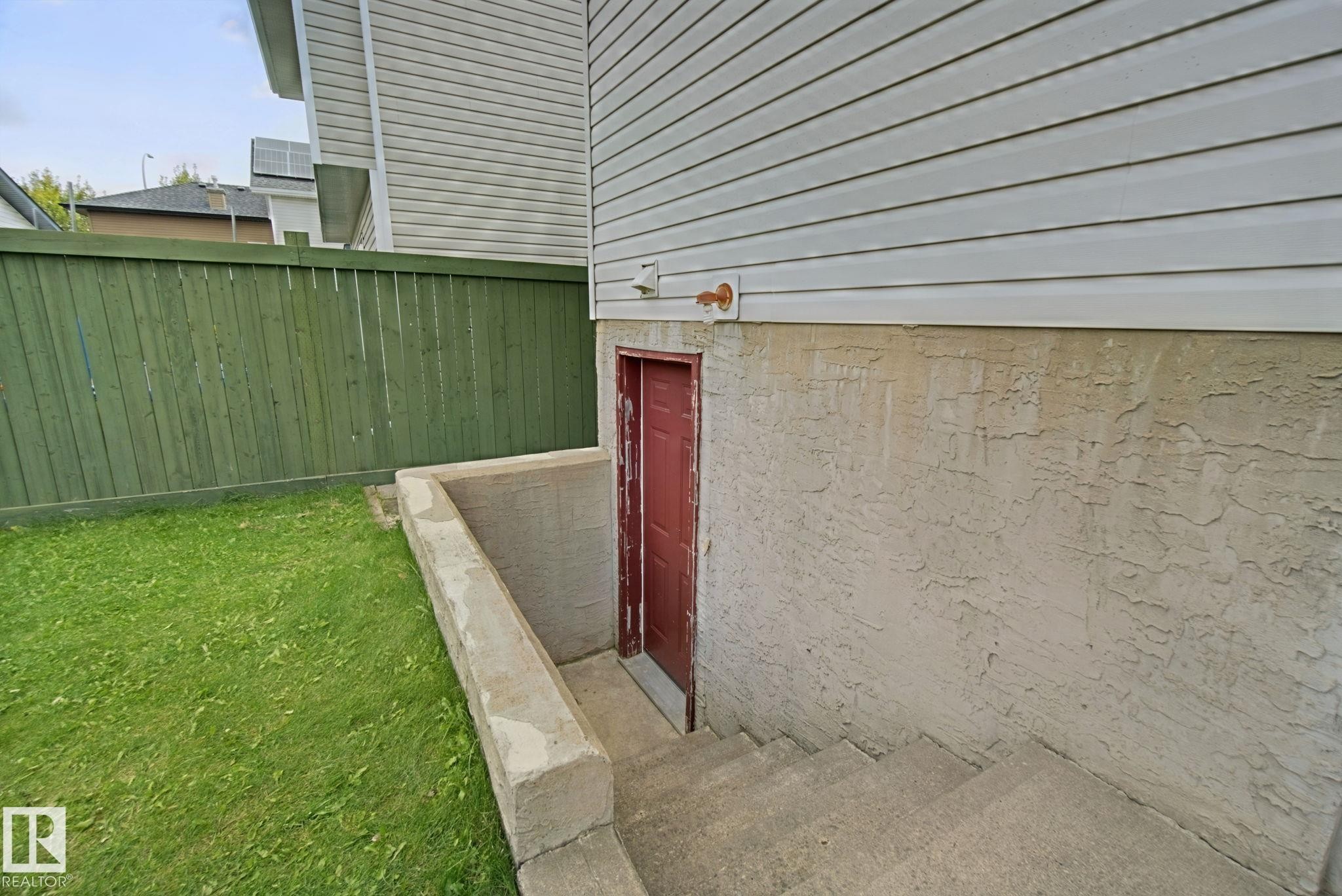Exterior with concrete basement access and red door - 13912 156 Avenue Nw, Edmonton, AB