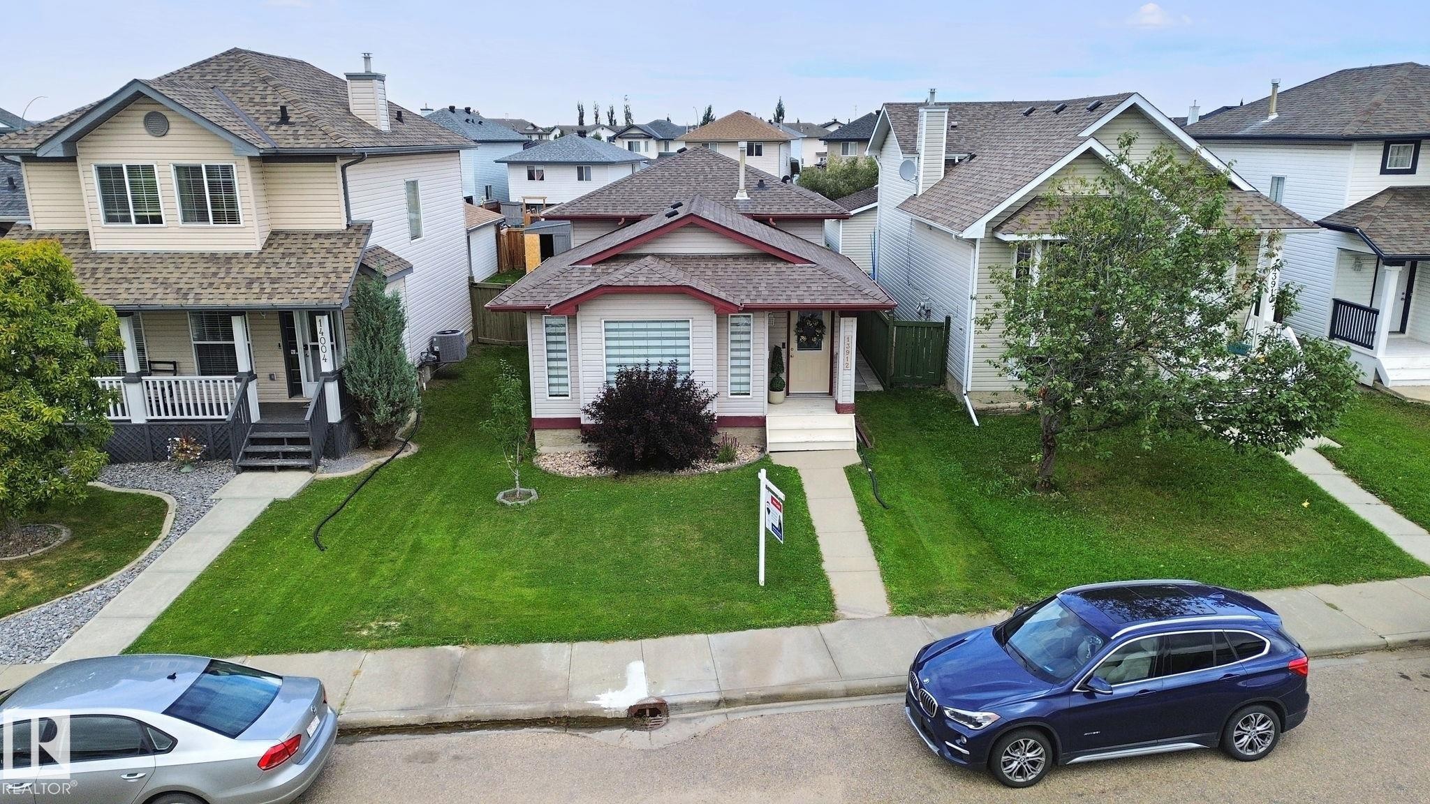 Single-story residence featuring a front lawn, concrete walkway, and a partial stone facade - 13912 156 Avenue Nw, Edmonton, AB