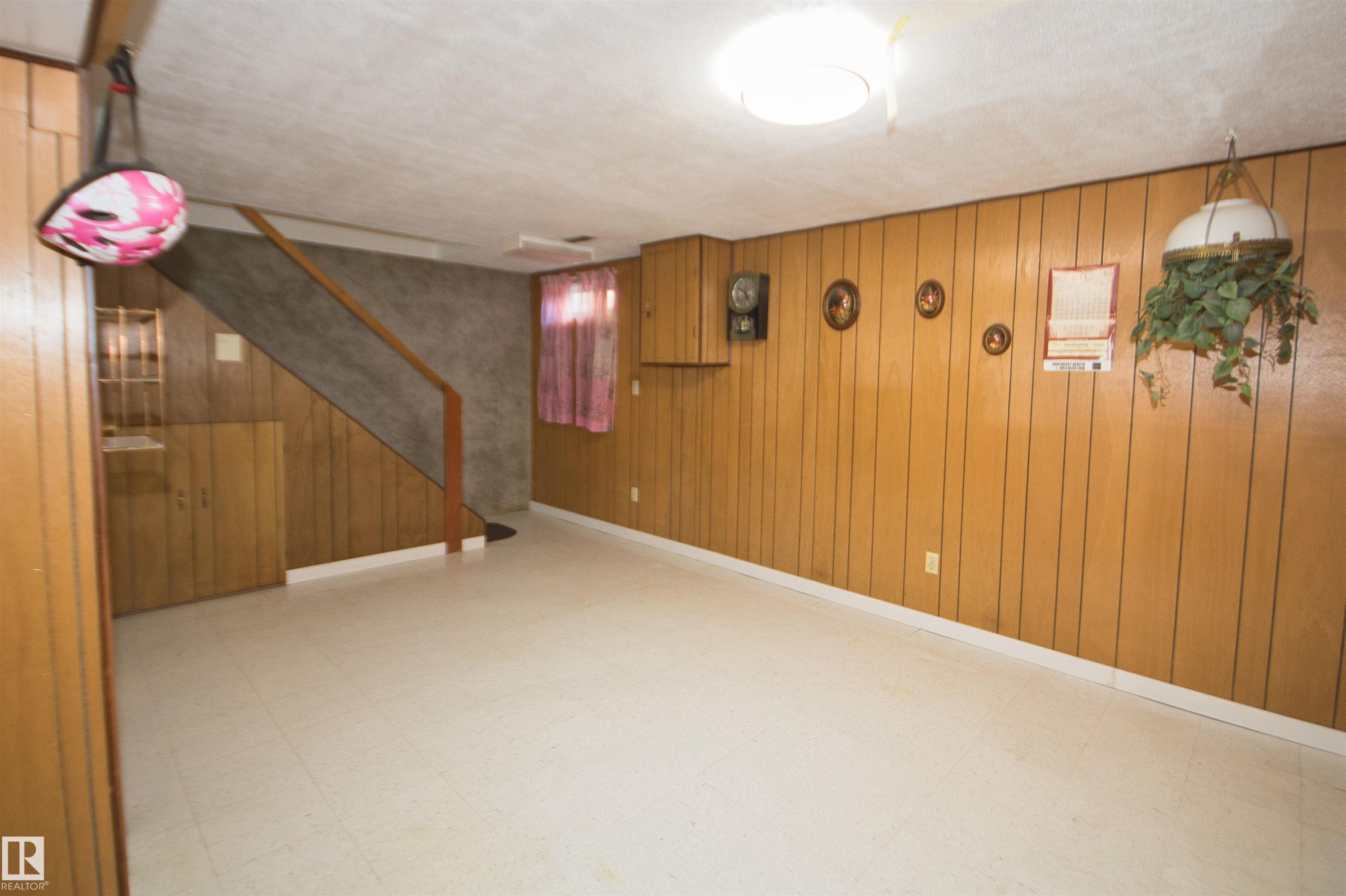 Vinyl flooring, wood panel wall accents, built-in cabinetry, and a ceiling-mounted light fixture - 7743 37 Avenue Nw, Edmonton, AB
