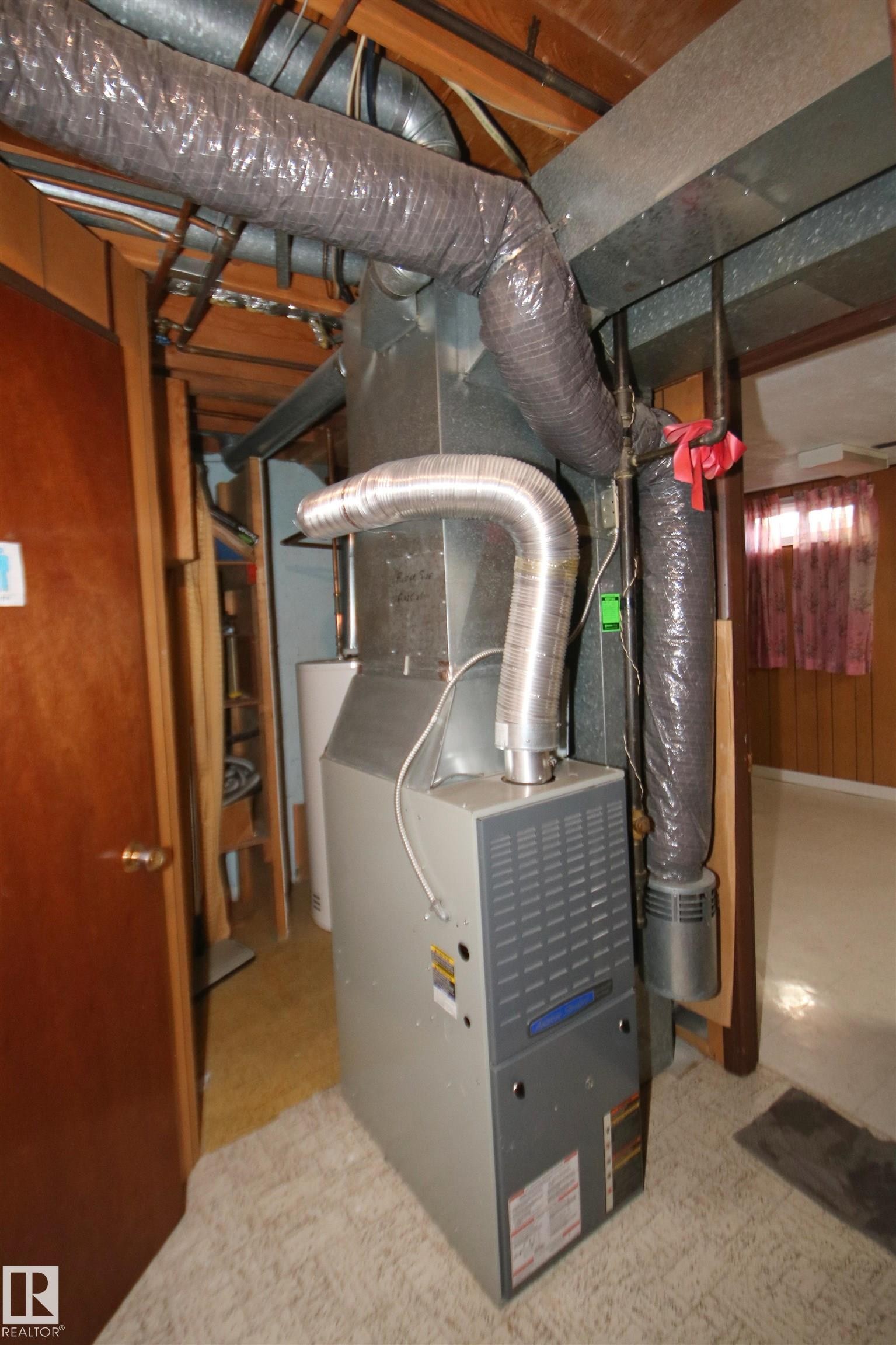 Central HVAC unit with exposed ductwork and wood ceiling joists - 7743 37 Avenue Nw, Edmonton, AB