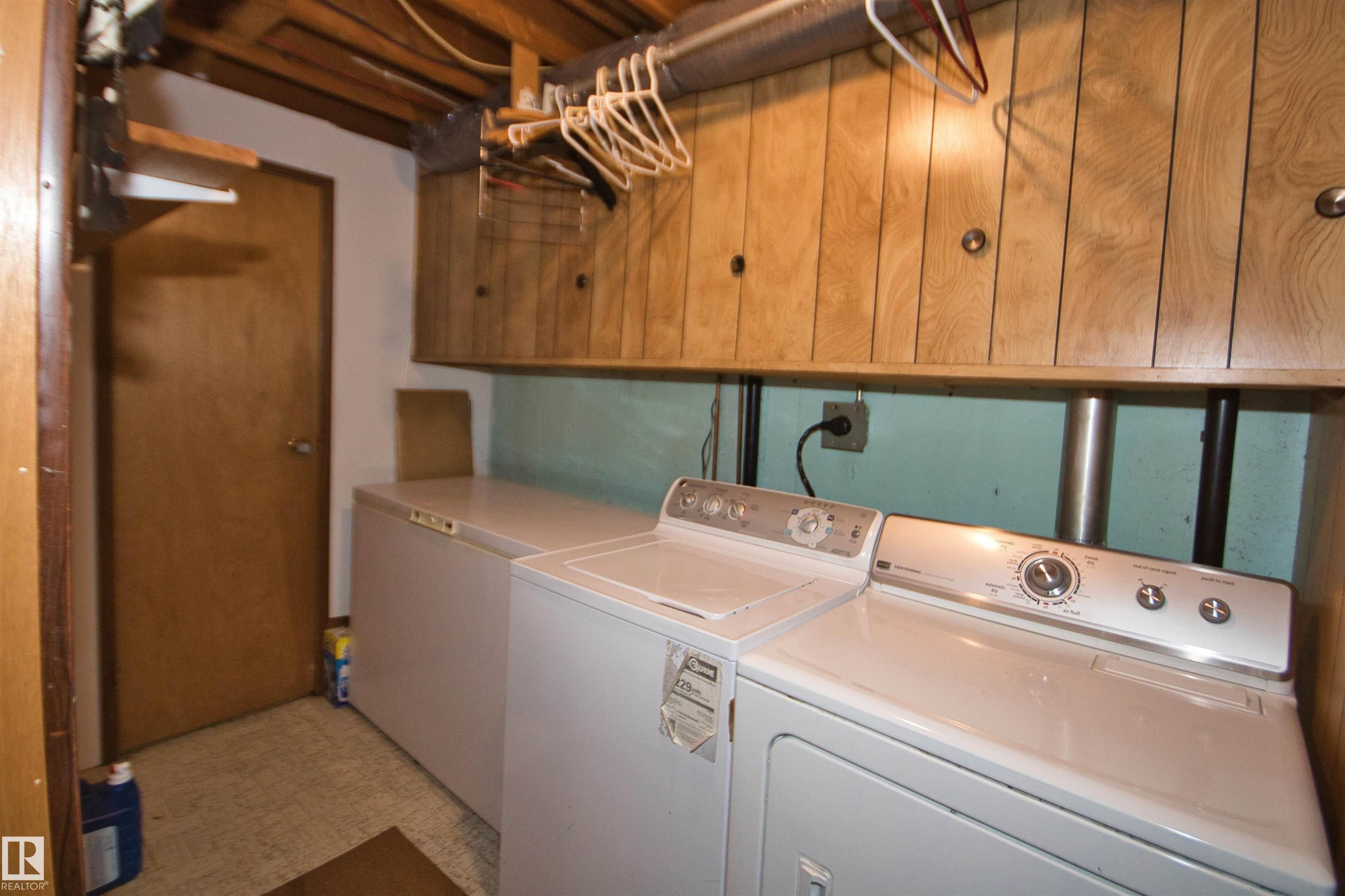 Wood-finish wall paneling, overhead wood cabinetry, and a ceiling-mounted light fixture - 7743 37 Avenue Nw, Edmonton, AB