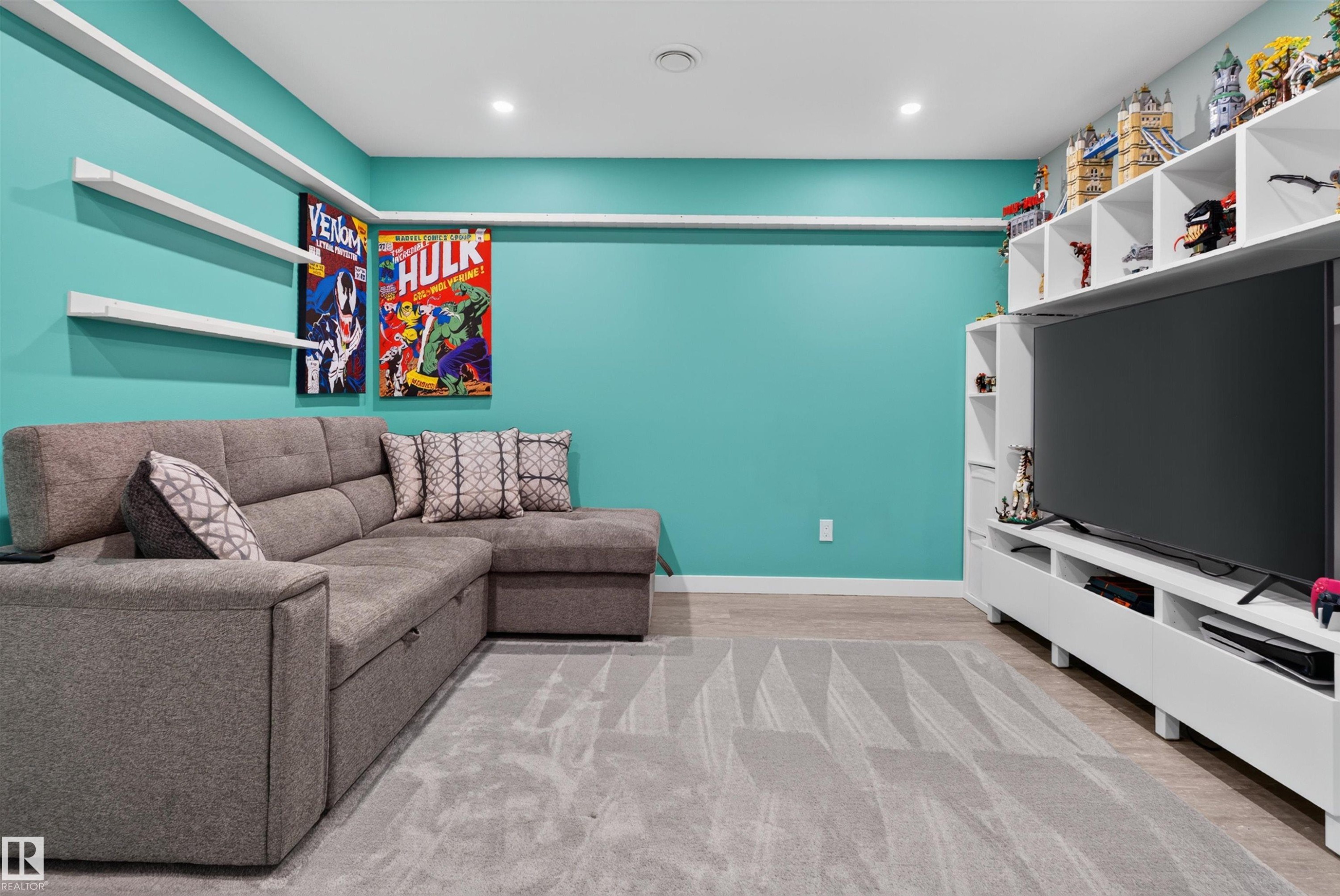Built-in shelving, wall-mounted display shelves, recessed lighting, wood-finish flooring, and a large area rug - 319 Desrochers Boulevard Sw, Edmonton, AB