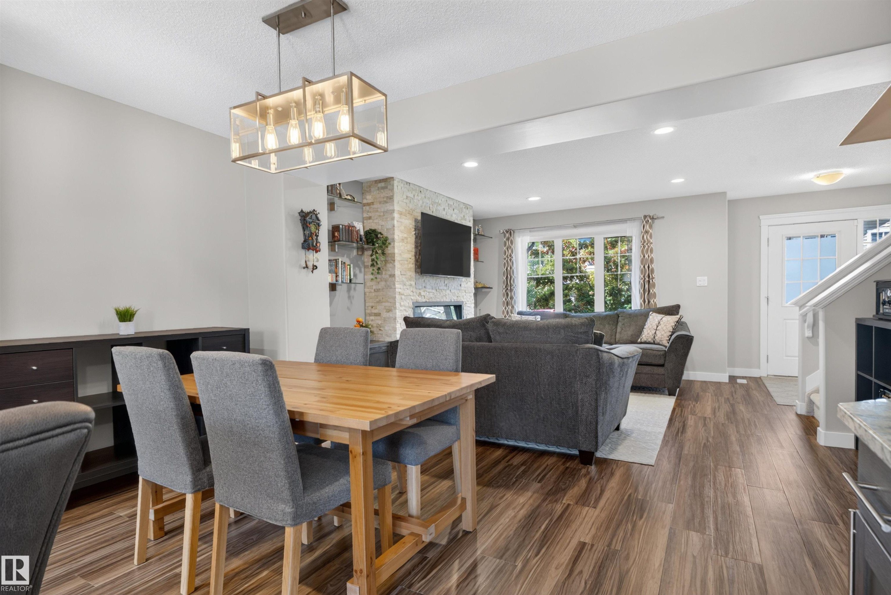 Wood-finish flooring throughout, recessed lighting, and a modern rectangular chandelier - 319 Desrochers Boulevard Sw, Edmonton, AB
