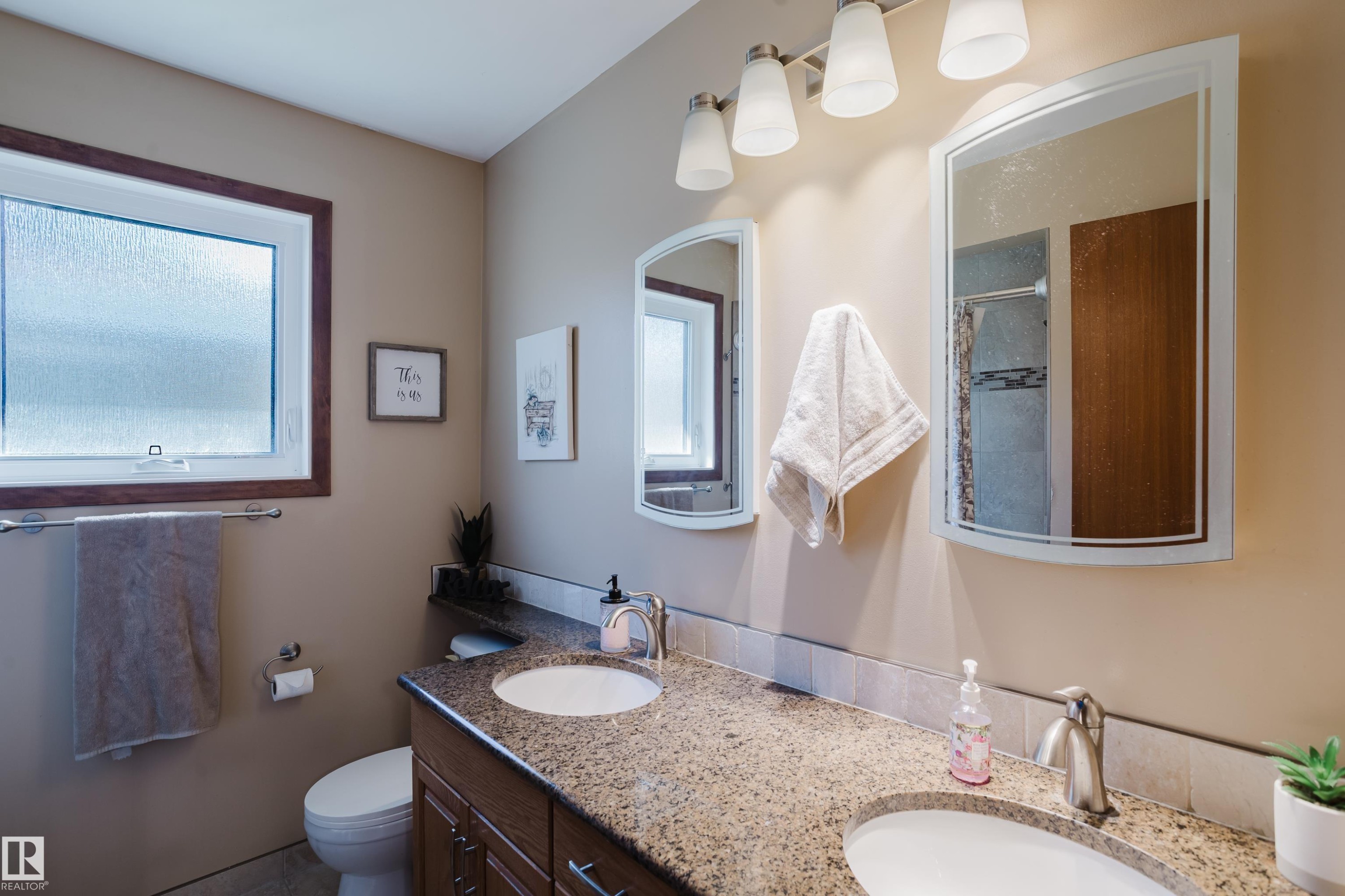 Dual vanity with integrated sinks, granite-finish countertop, and brushed nickel fixtures - 10924 35A Avenue Nw, Edmonton, AB