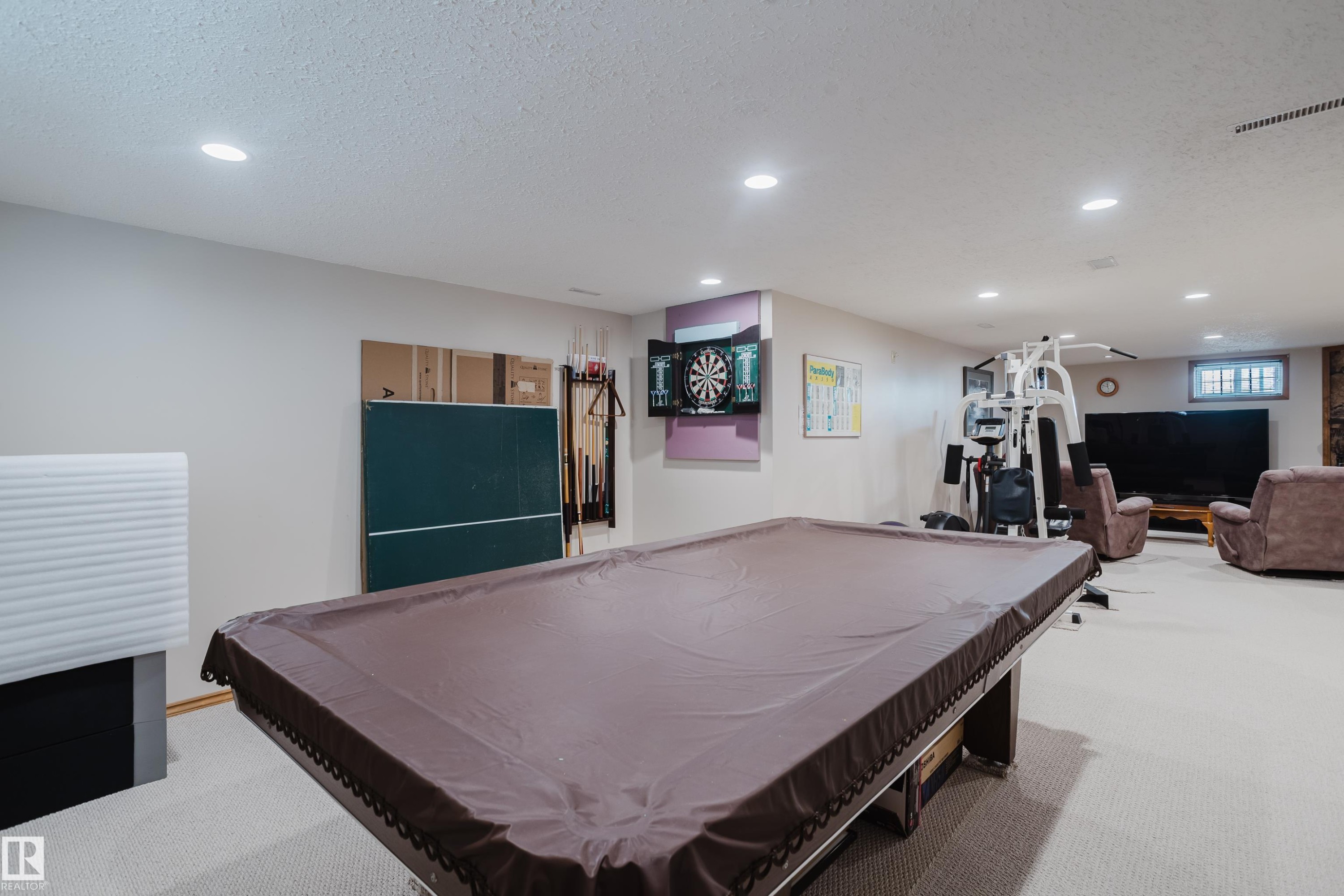 Recessed lighting illuminates the open area with light-toned carpeting - 10924 35A Avenue Nw, Edmonton, AB
