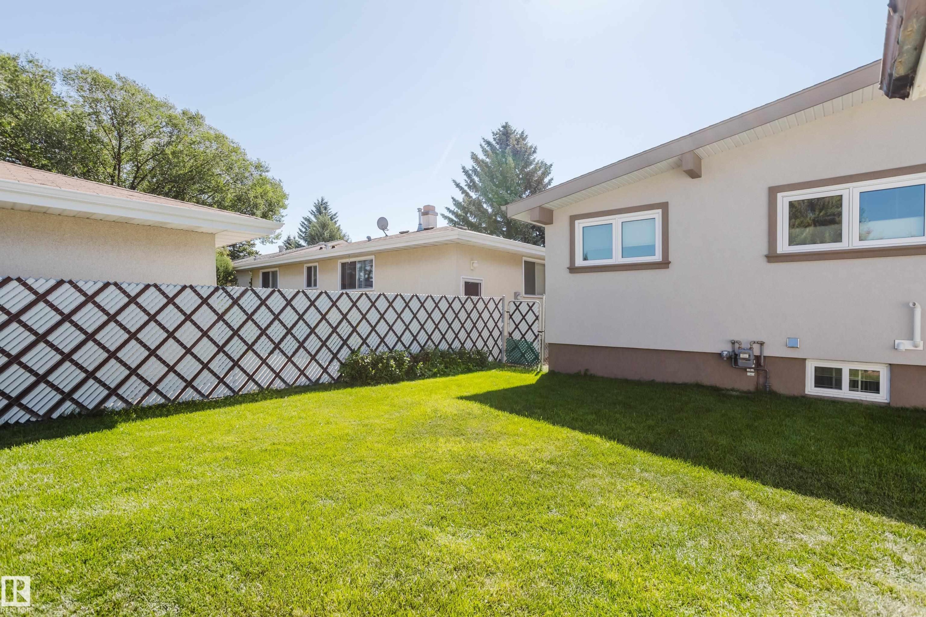 Expansive lawn area with a decorative privacy screen - 10924 35A Avenue Nw, Edmonton, AB