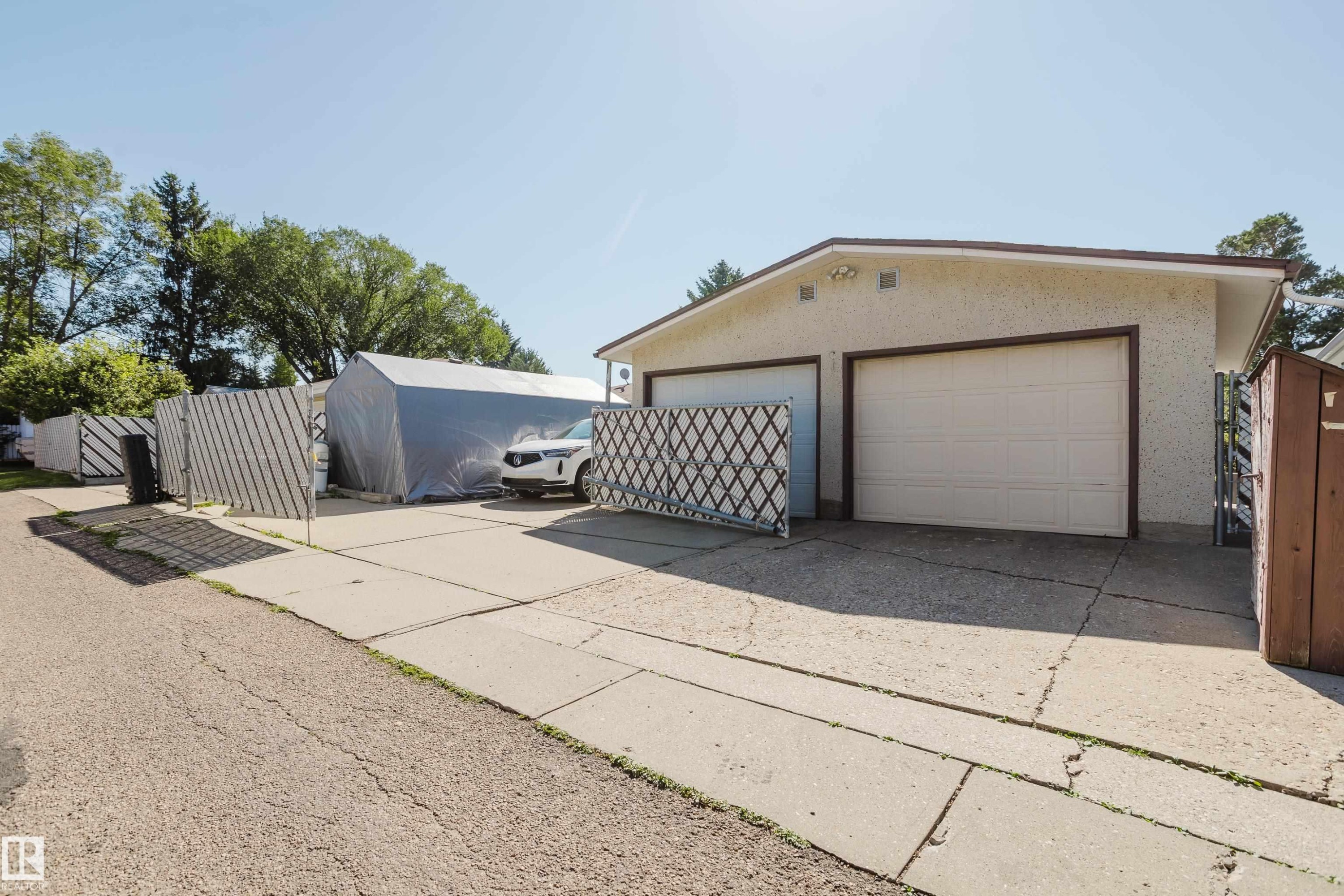 Two-car garage with overhead doors and exterior wall lights - 10924 35A Avenue Nw, Edmonton, AB