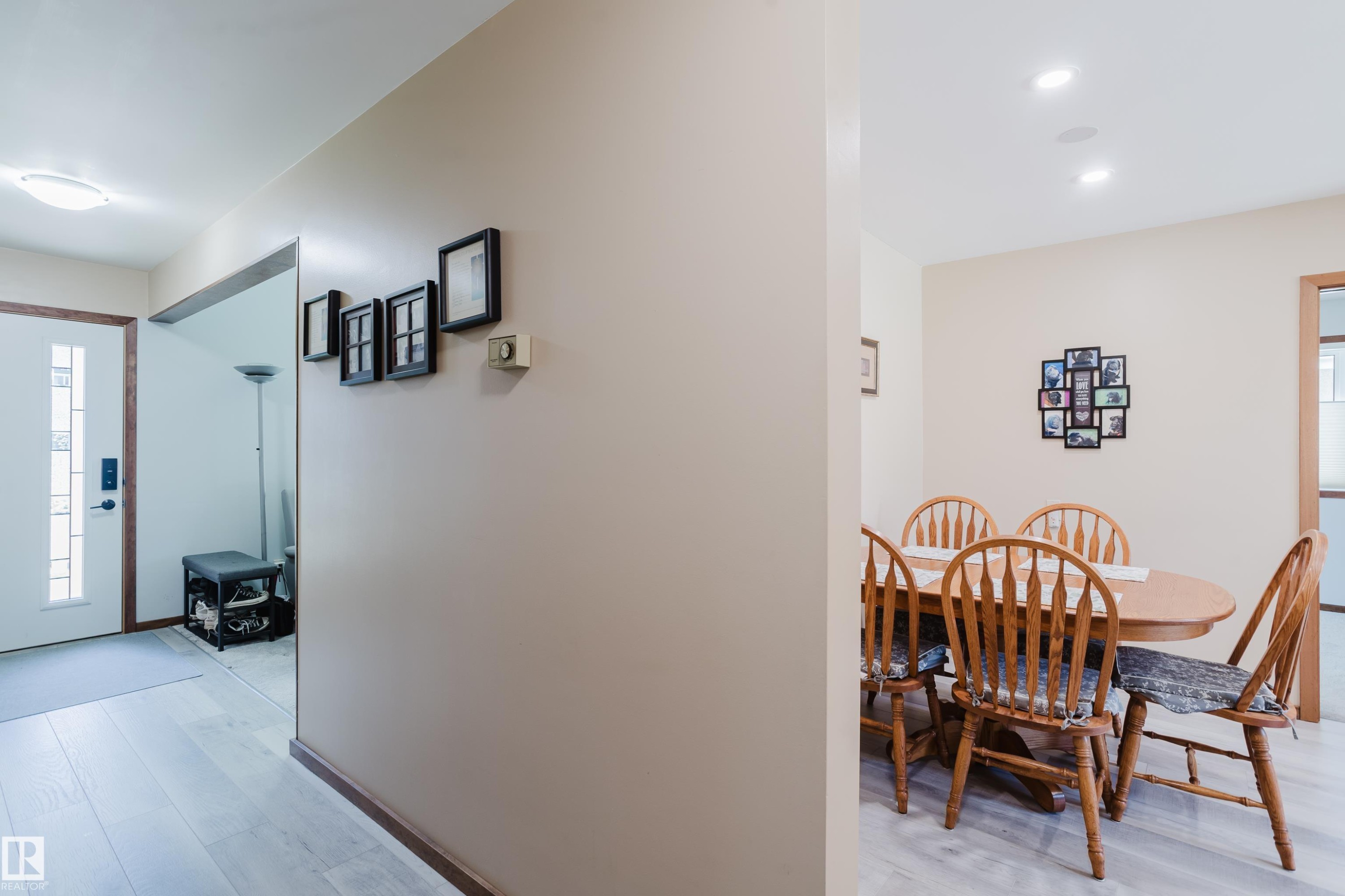 Entryway with light wood-finish flooring, a white paneled door with decorative glass inserts, and a flush-mount ceiling light fixture - 10924 35A Avenue Nw, Edmonton, AB