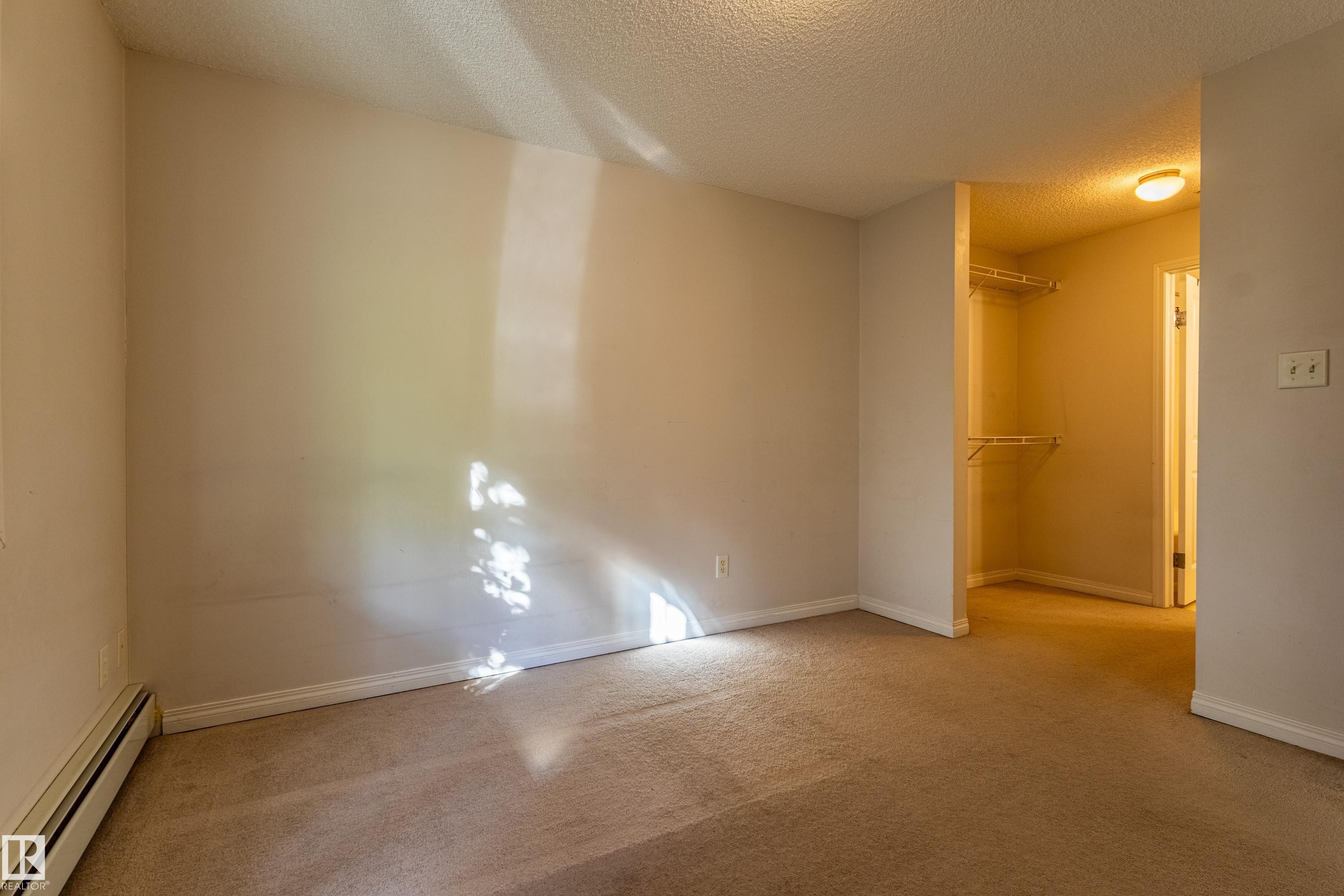 Plush carpeting, neutral wall tones, and an integrated walk-in closet with shelving - #316 11325 83 St Nw, Edmonton, AB