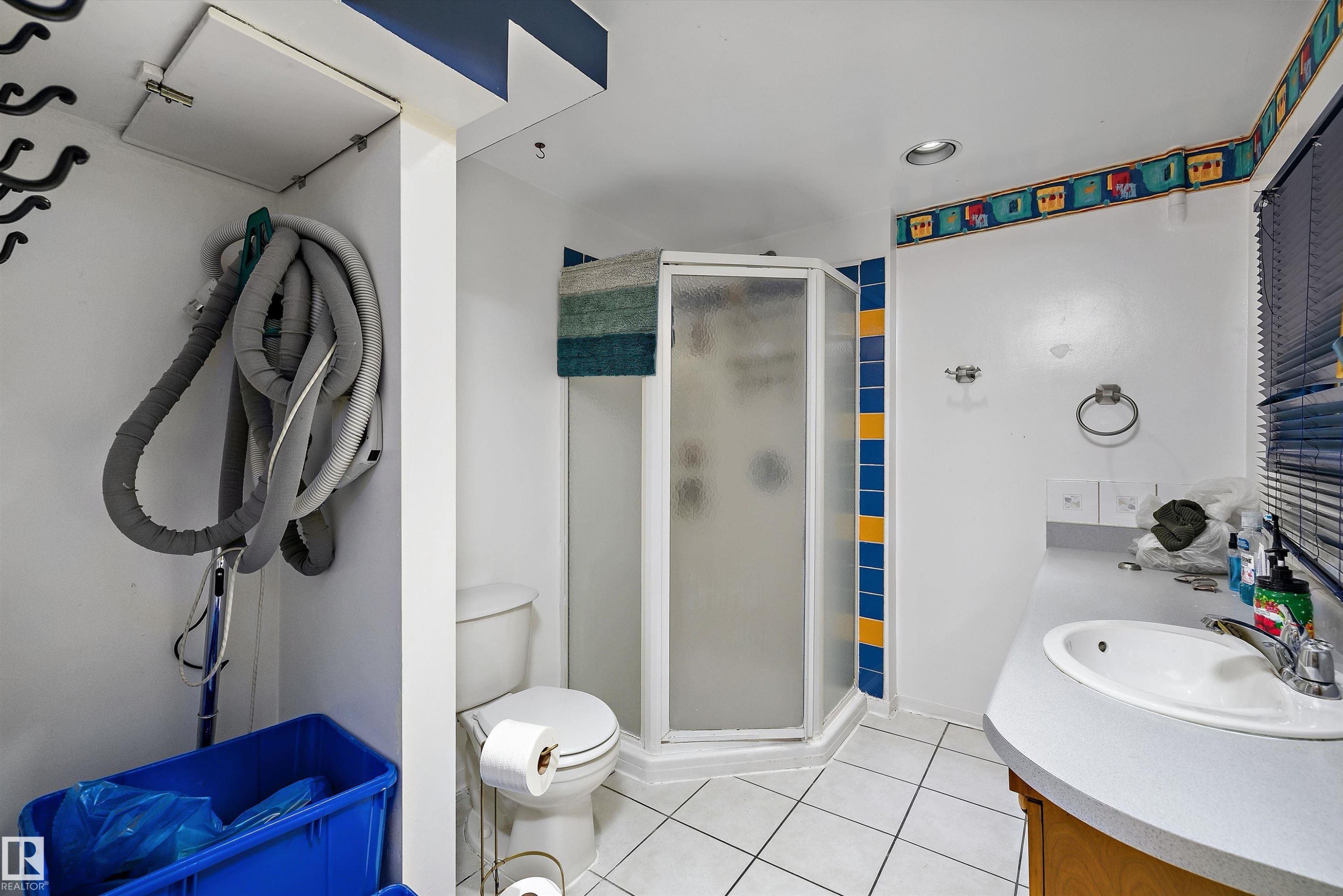 Tiled flooring with a corner shower enclosure, single vanity with integrated sink, and recessed lighting - 10621 60A Avenue Nw, Edmonton, AB