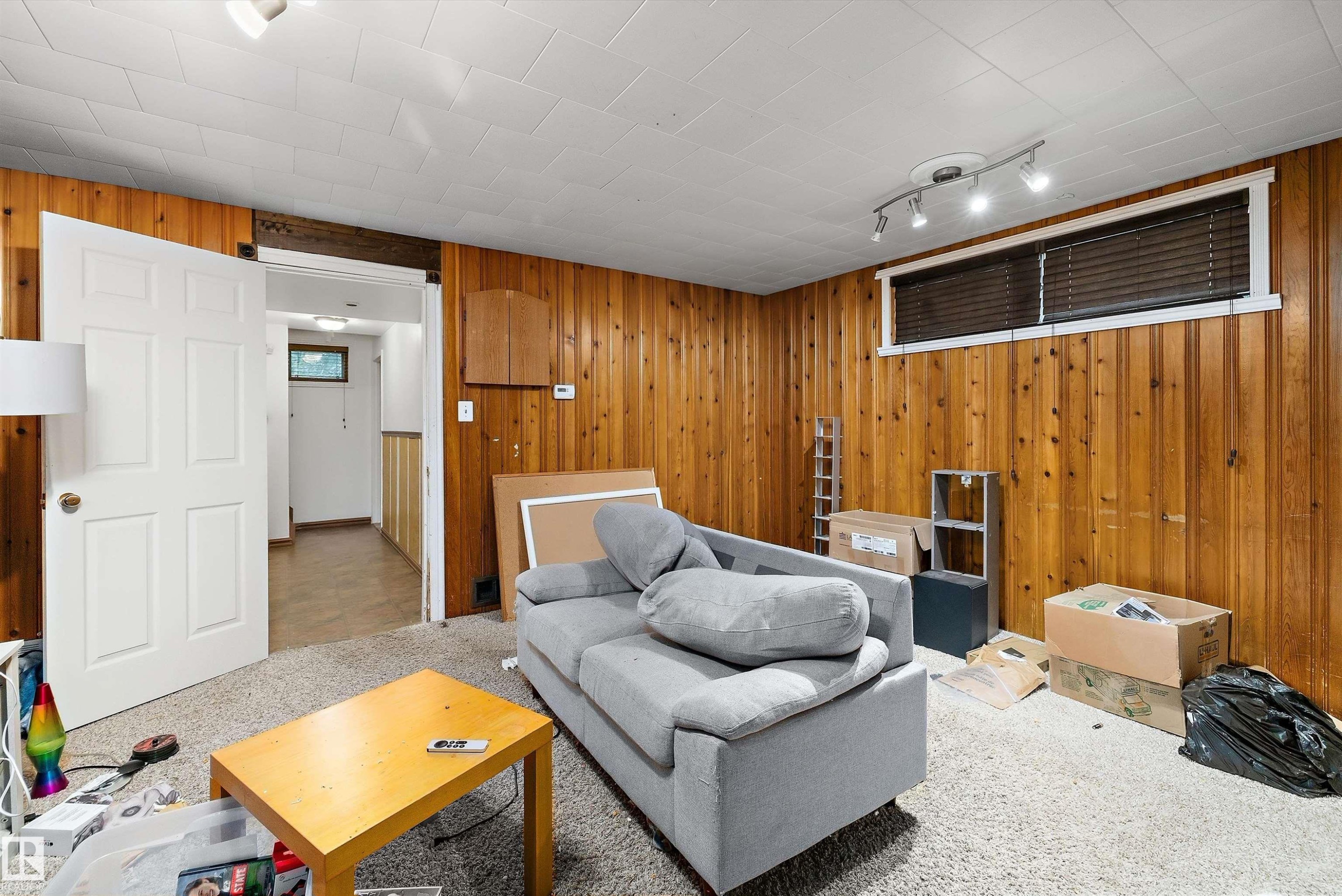 Interior space featuring wood paneling, white paneled door, and recessed window - 10621 60A Avenue Nw, Edmonton, AB