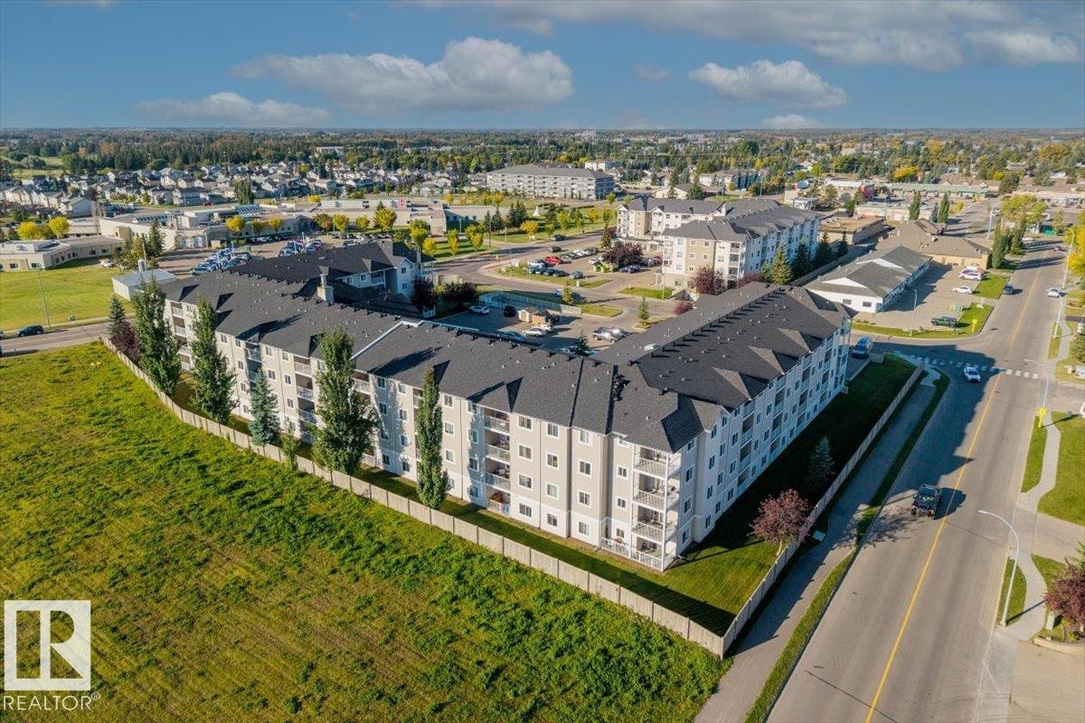 Multi-story building featuring light-toned exterior siding and private balconies - #110 4309 33 St, Stony Plain, AB