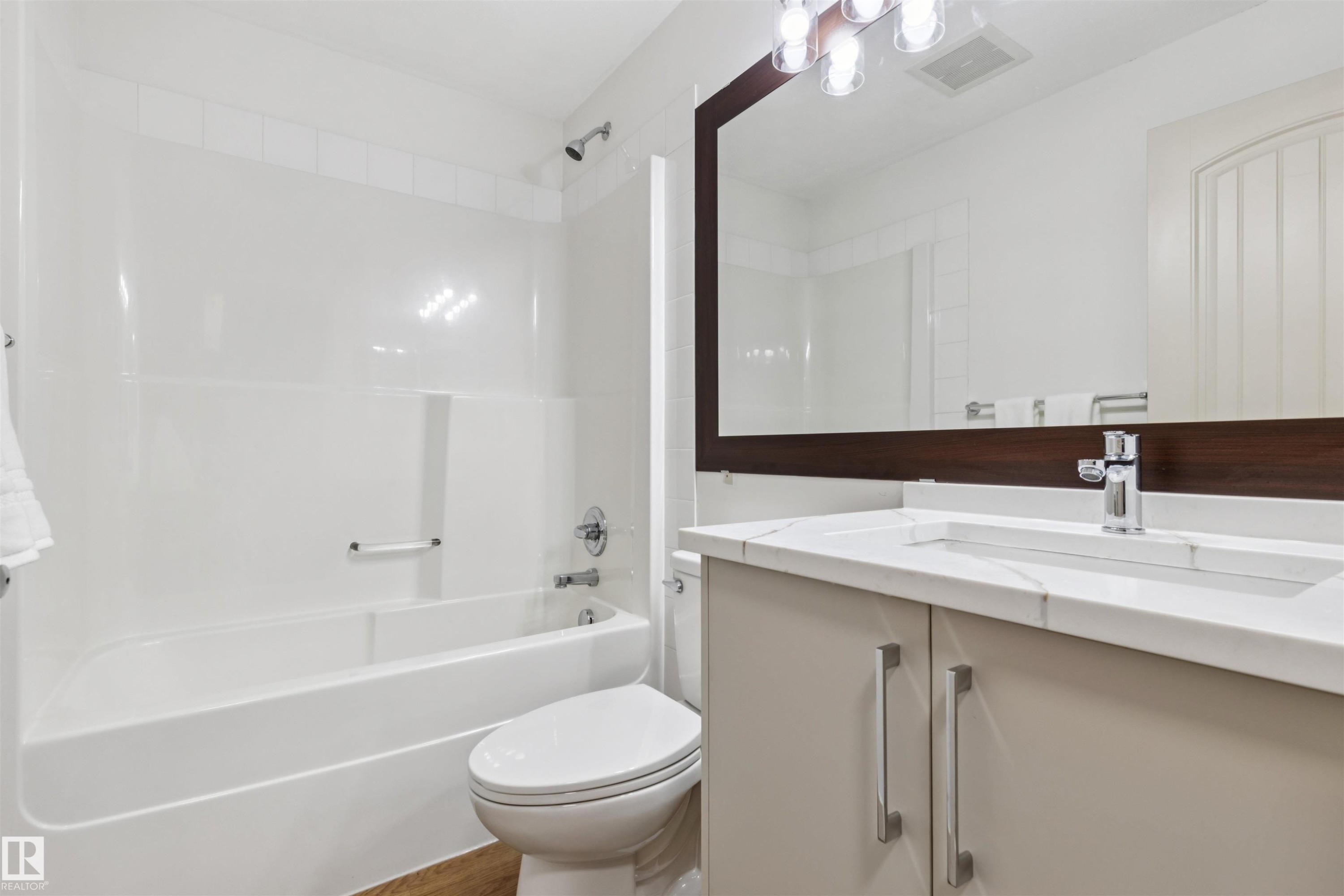 Bathroom featuring a single vanity with a solid surface countertop, integrated sink, and chrome faucet - #353 2096 Blackmud Creek Dr Sw, Edmonton, AB - Indoor Photo Showing Bathroom
