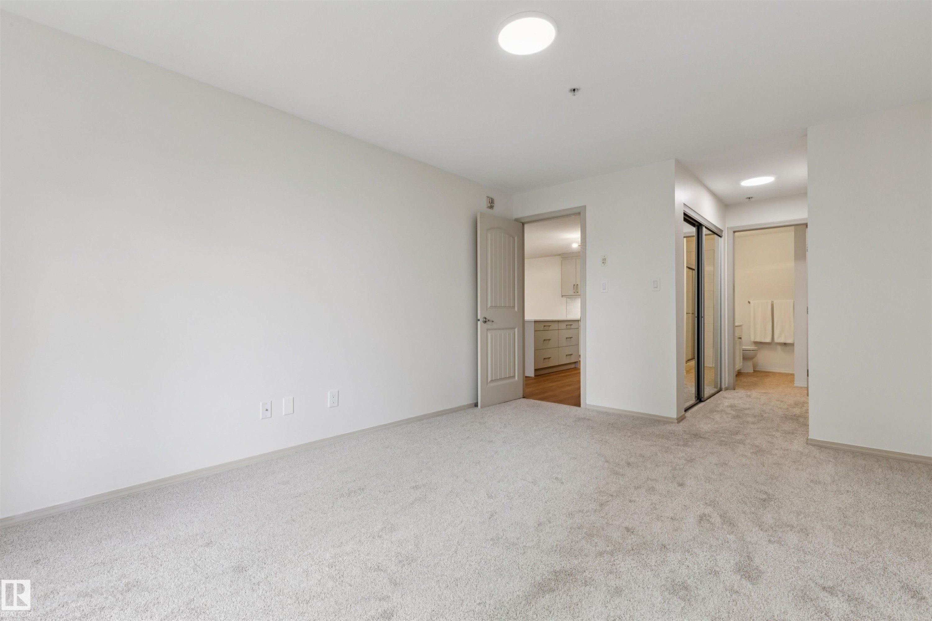 Spacious room featuring light gray carpeting and white painted walls - #353 2096 Blackmud Creek Dr Sw, Edmonton, AB - Indoor Photo Showing Other Room
