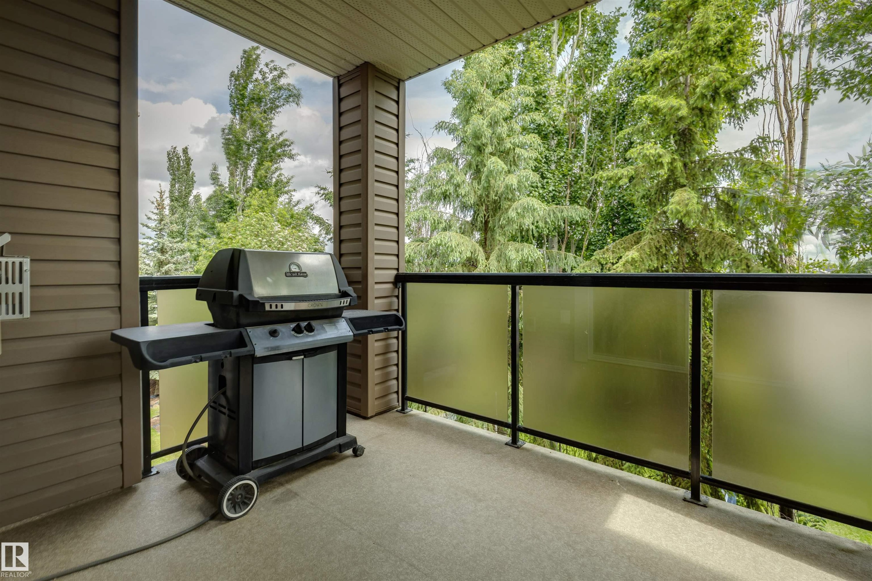 Private patio featuring durable siding, a concrete surface, and a frosted glass railing system - #353 2096 Blackmud Creek Dr Sw, Edmonton, AB - Outdoor With Balcony With Exterior