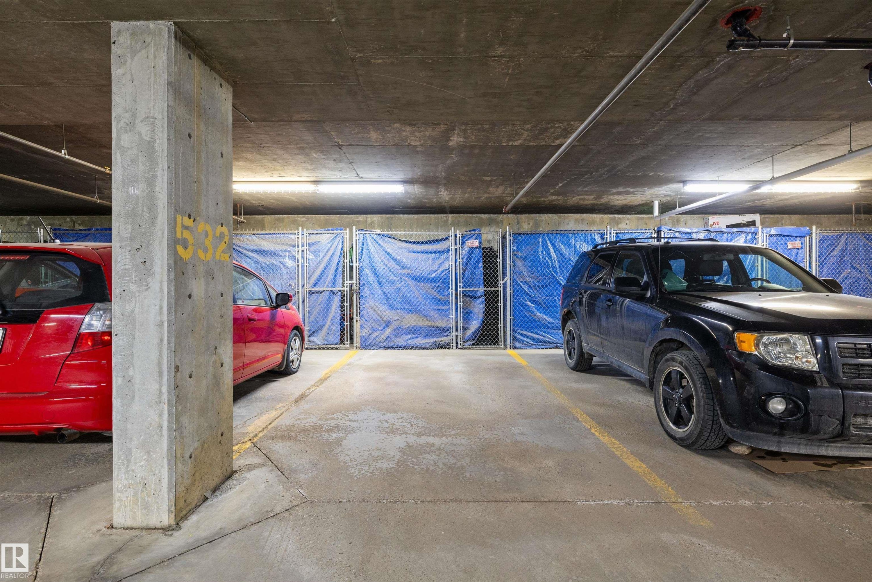Concrete parking structure featuring designated parking spaces with painted yellow lines - #353 2096 Blackmud Creek Dr Sw, Edmonton, AB - Indoor Photo Showing Garage