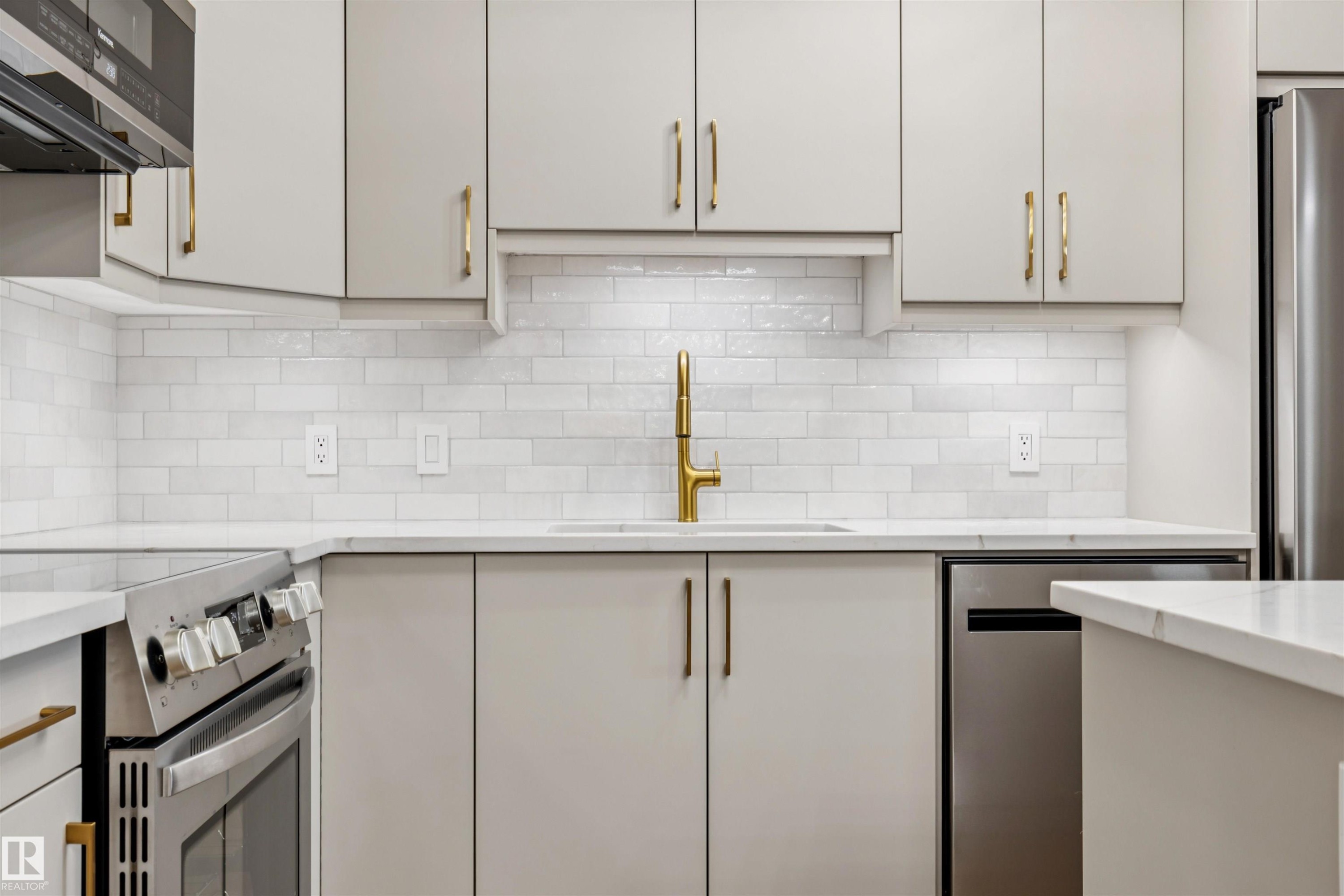 Contemporary kitchen featuring light gray cabinetry, white subway tile backsplash, and white countertops - #353 2096 Blackmud Creek Dr Sw, Edmonton, AB - Indoor Photo Showing Kitchen With Upgraded Kitchen