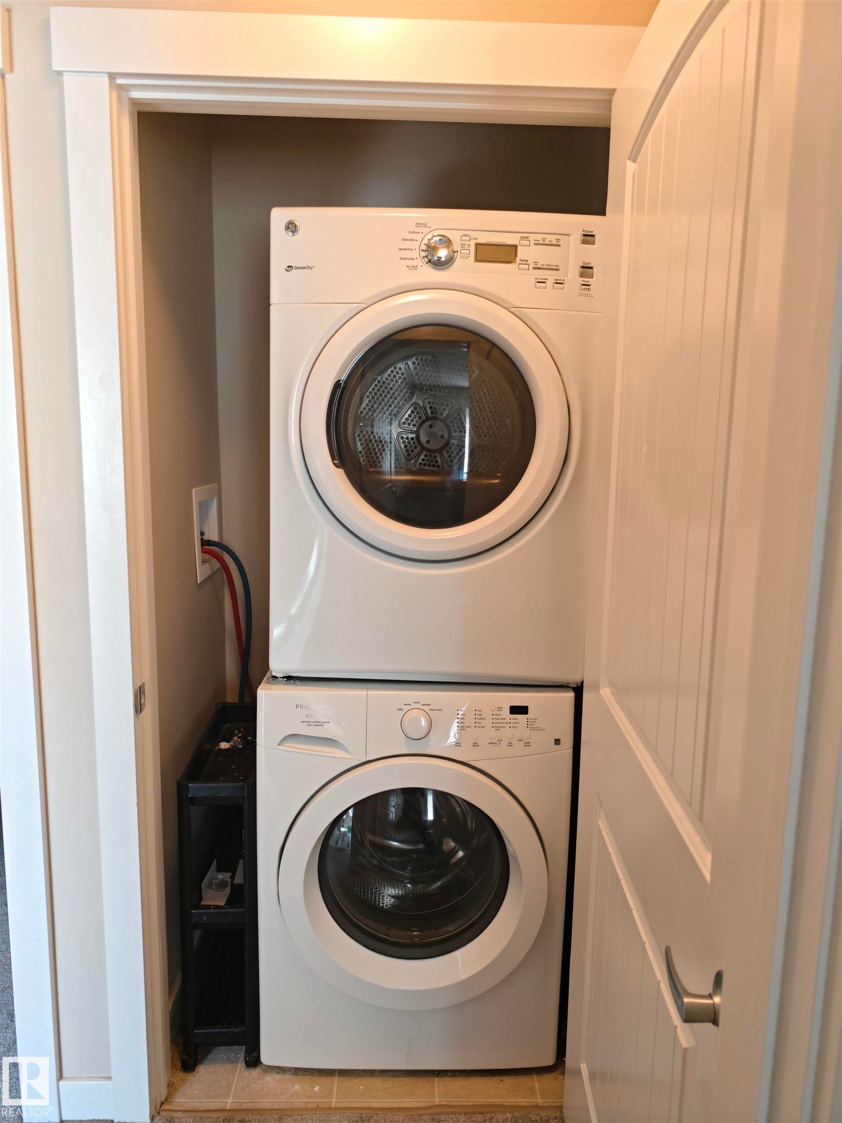 Dedicated laundry closet featuring a stacked washer and dryer - #20 8315 180 Av Nw, Edmonton, AB