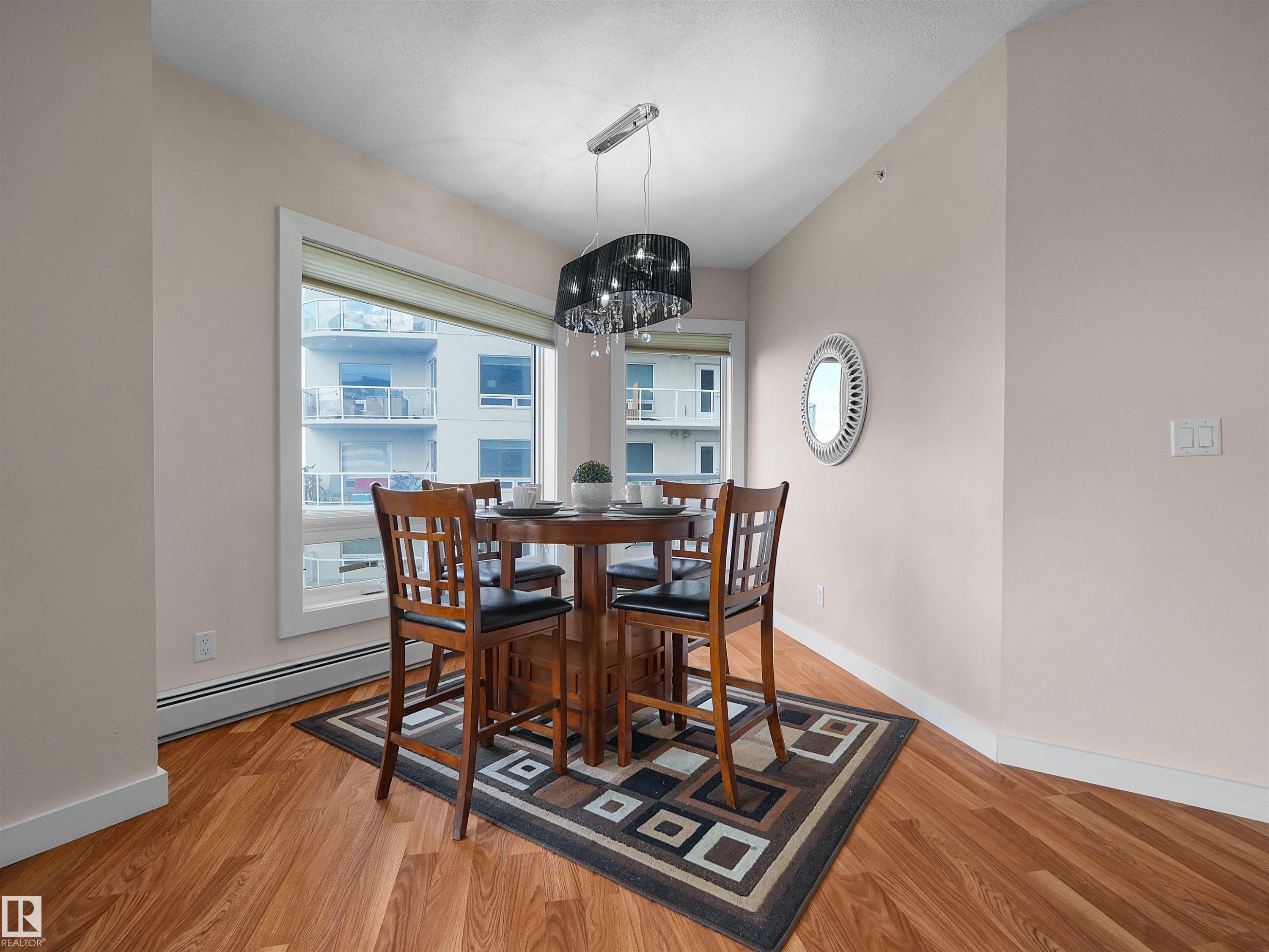 Wood-finish flooring throughout, complemented by a large window with white trim - #1601 10136 104 St Nw, Edmonton, AB