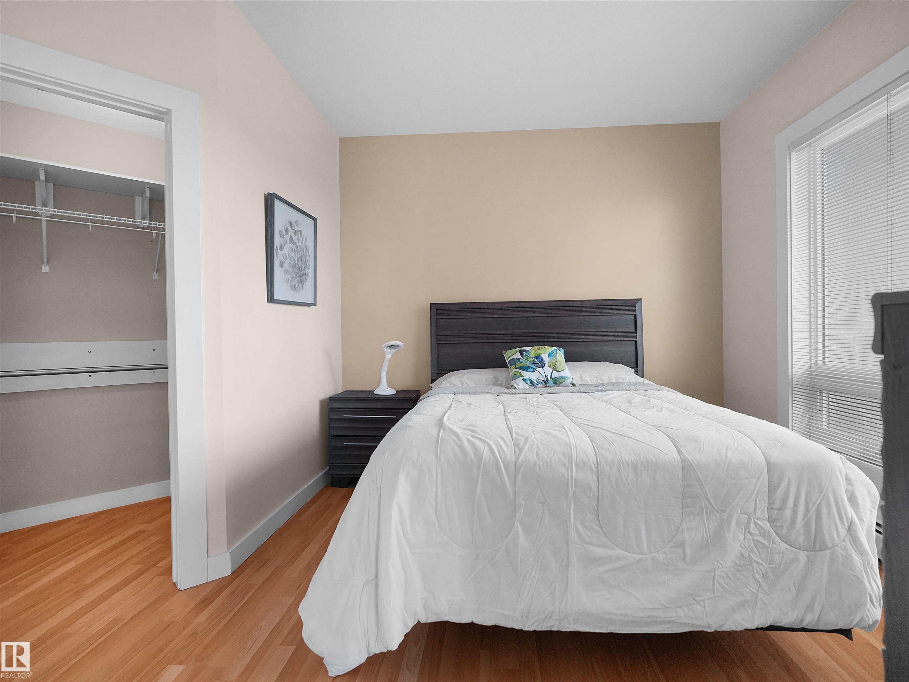 Hardwood flooring, painted walls, window with blinds, closet with wire shelving - #1601 10136 104 St Nw, Edmonton, AB