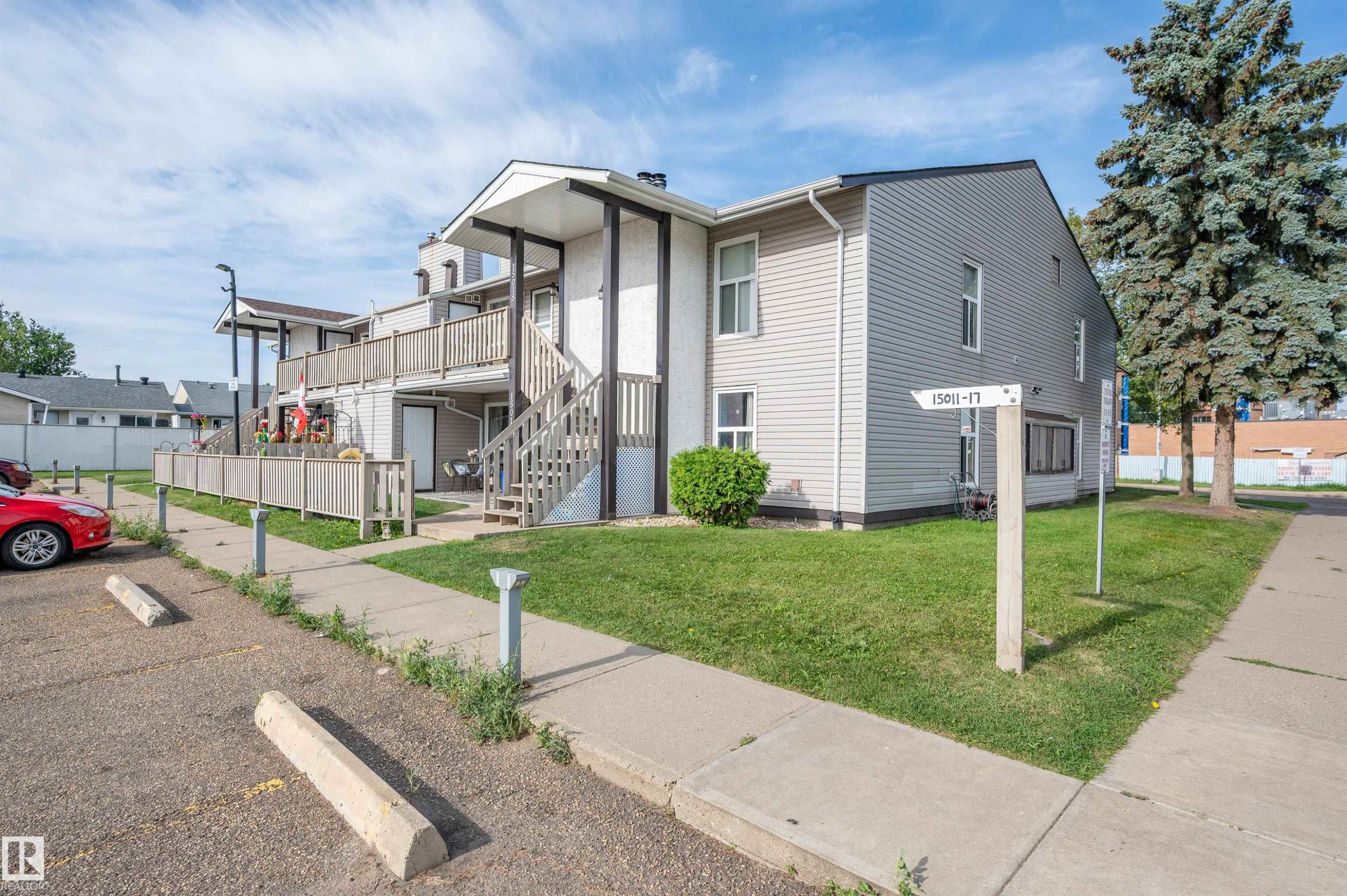 Multi-story building with light-toned siding and white trim - 15017 26 Street Nw, Edmonton, AB