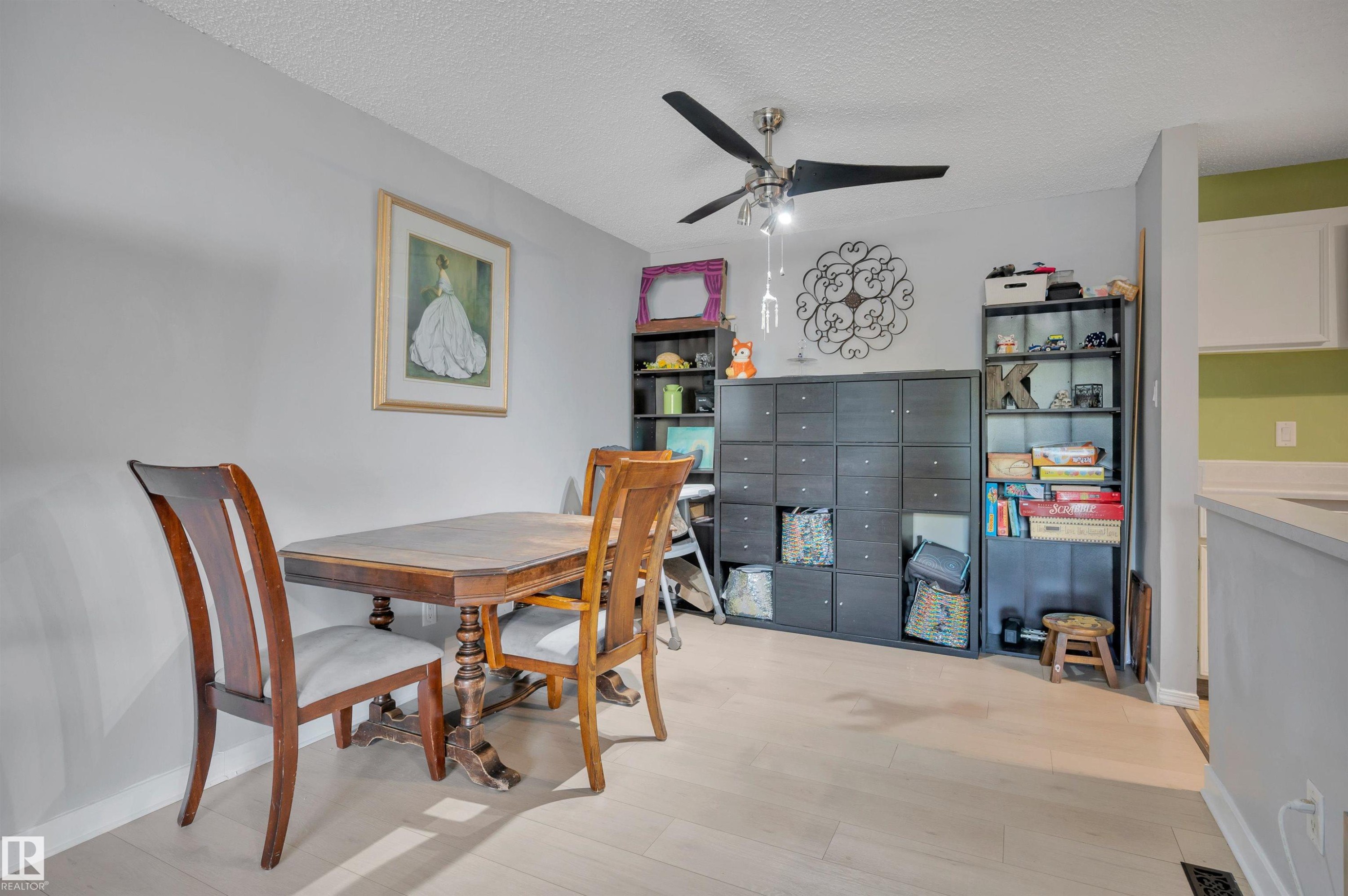 Light wood-finish flooring extending throughout the space - 15017 26 Street Nw, Edmonton, AB