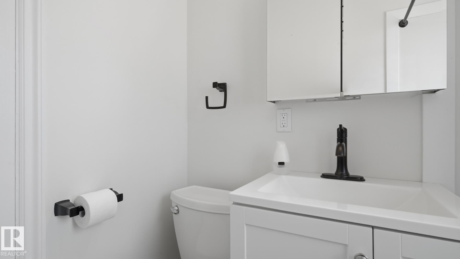 White vanity with integrated sink, bronze-finish faucet, and coordinating wall-mounted storage cabinet - 11836 62 Street Nw, Edmonton, AB