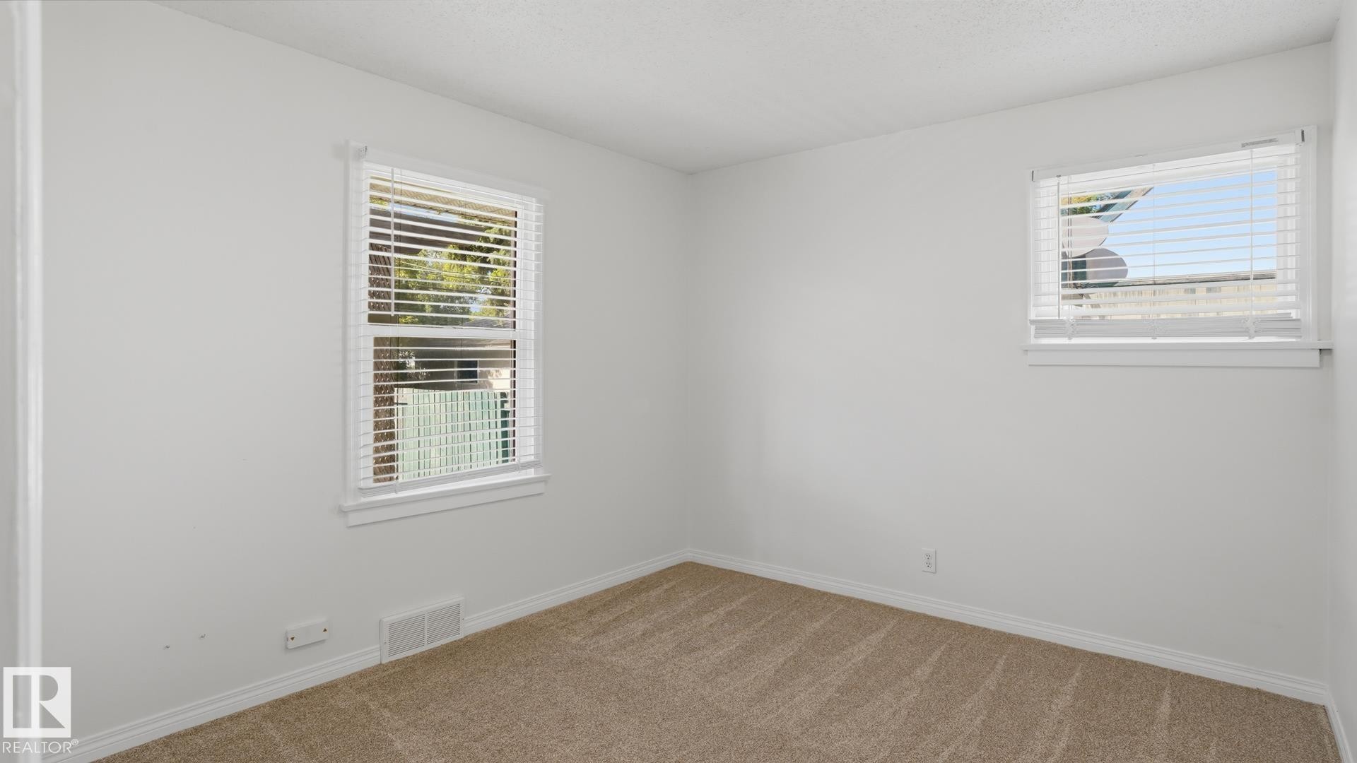 Neutral wall paint, two windows with blinds, and carpeted flooring - 11836 62 Street Nw, Edmonton, AB