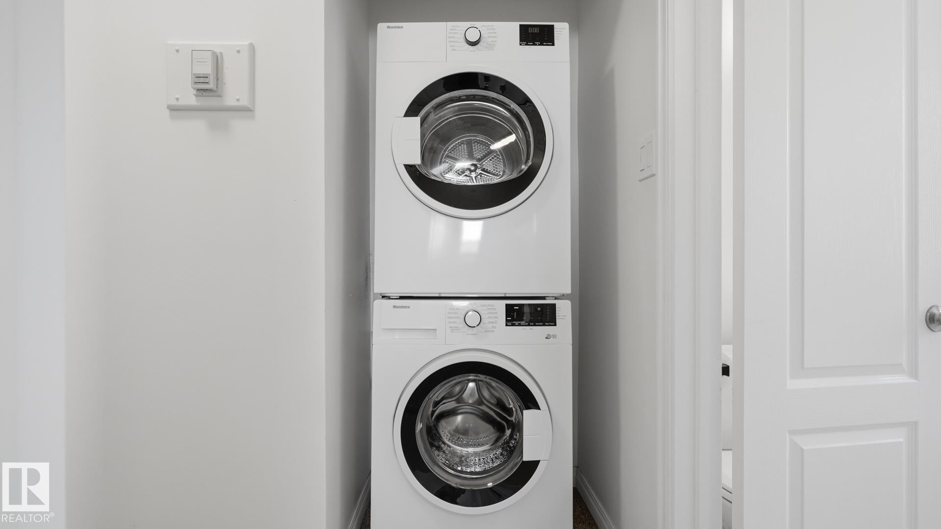 Stacked white front-loading washer and dryer units - 11836 62 Street Nw, Edmonton, AB