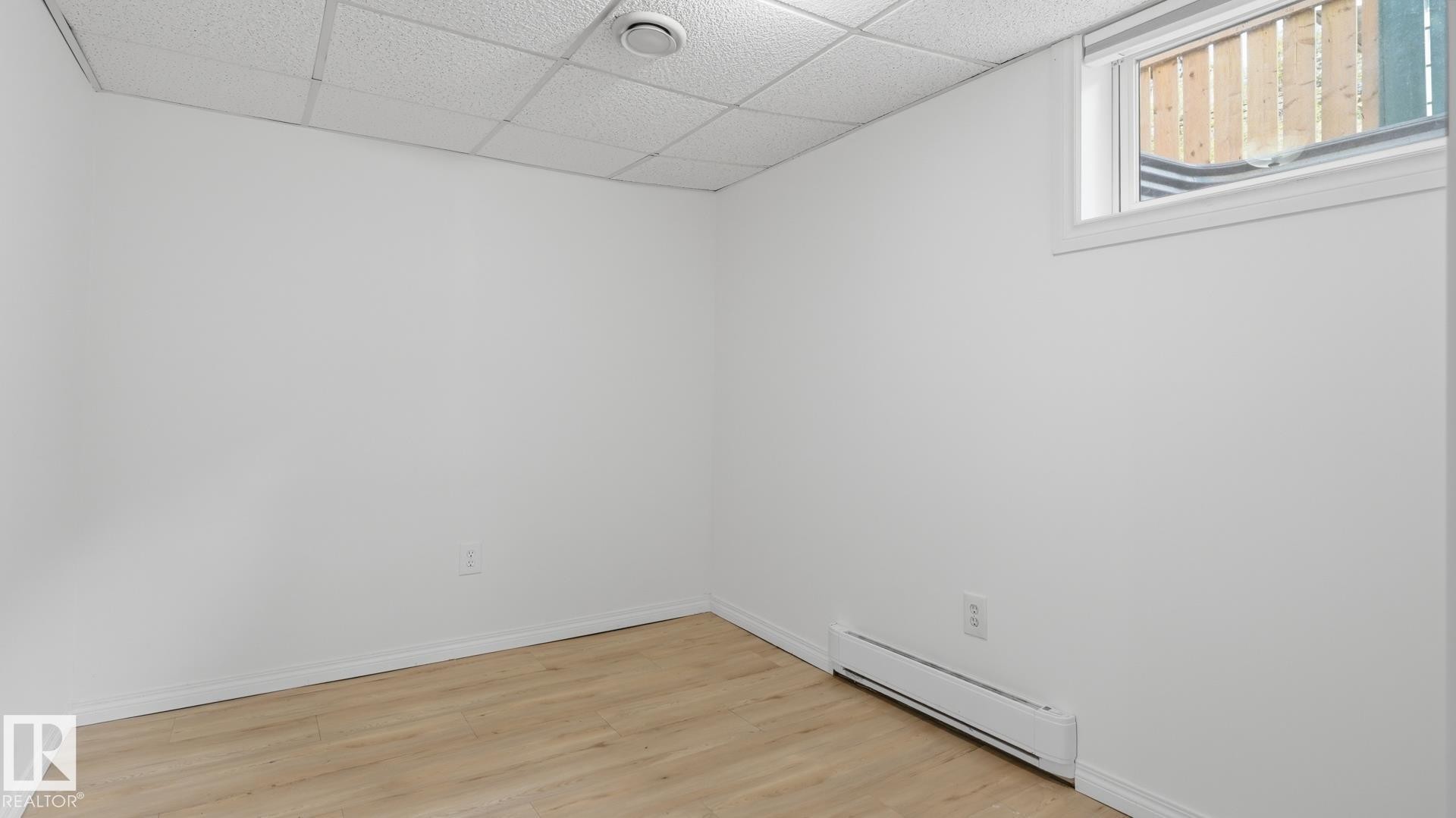 Recessed window with white trim, wood-finish flooring, white walls, and a drop-panel ceiling - 11836 62 Street Nw, Edmonton, AB