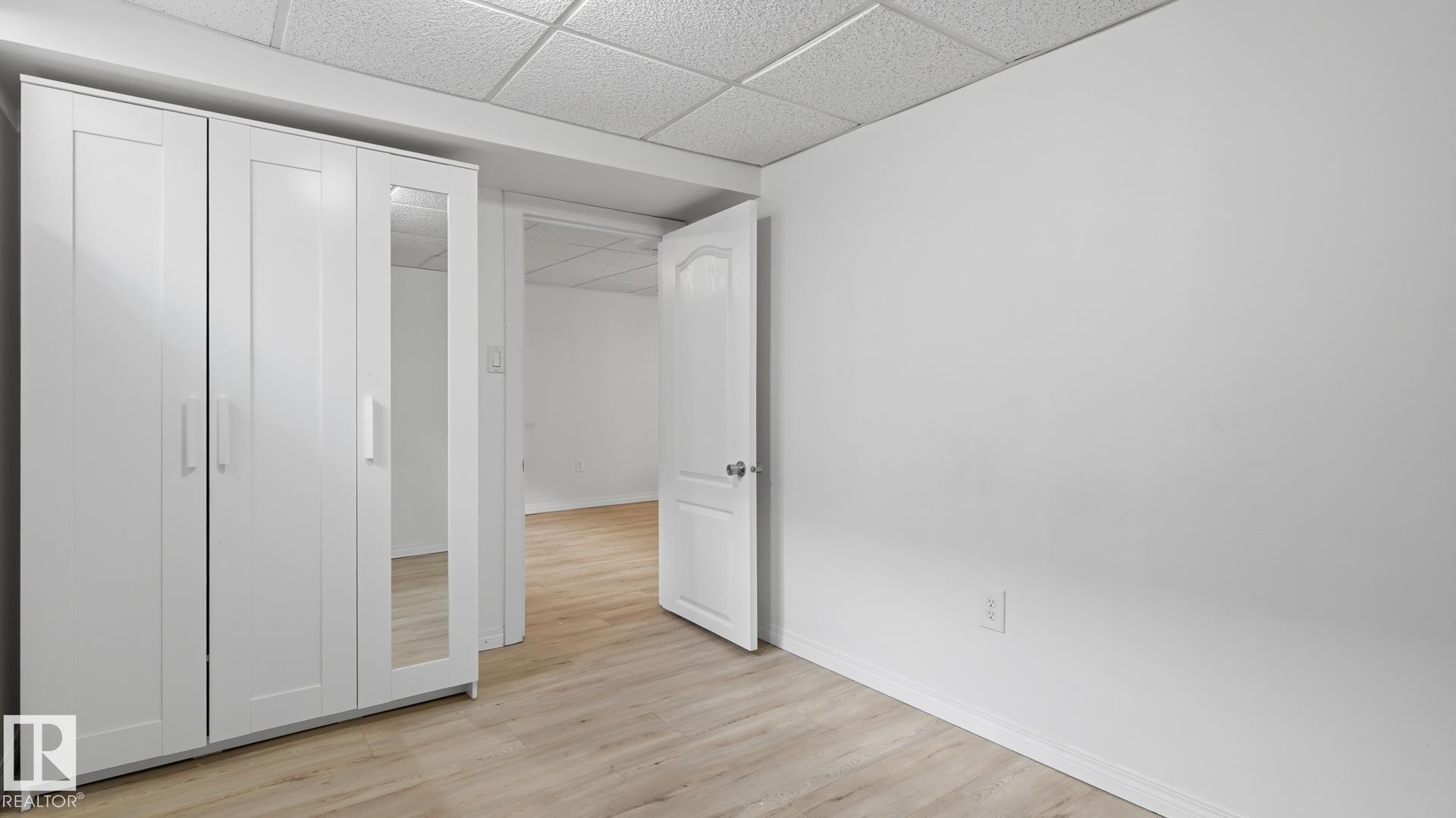 Light wood-finish flooring with white walls and trim - 11836 62 Street Nw, Edmonton, AB